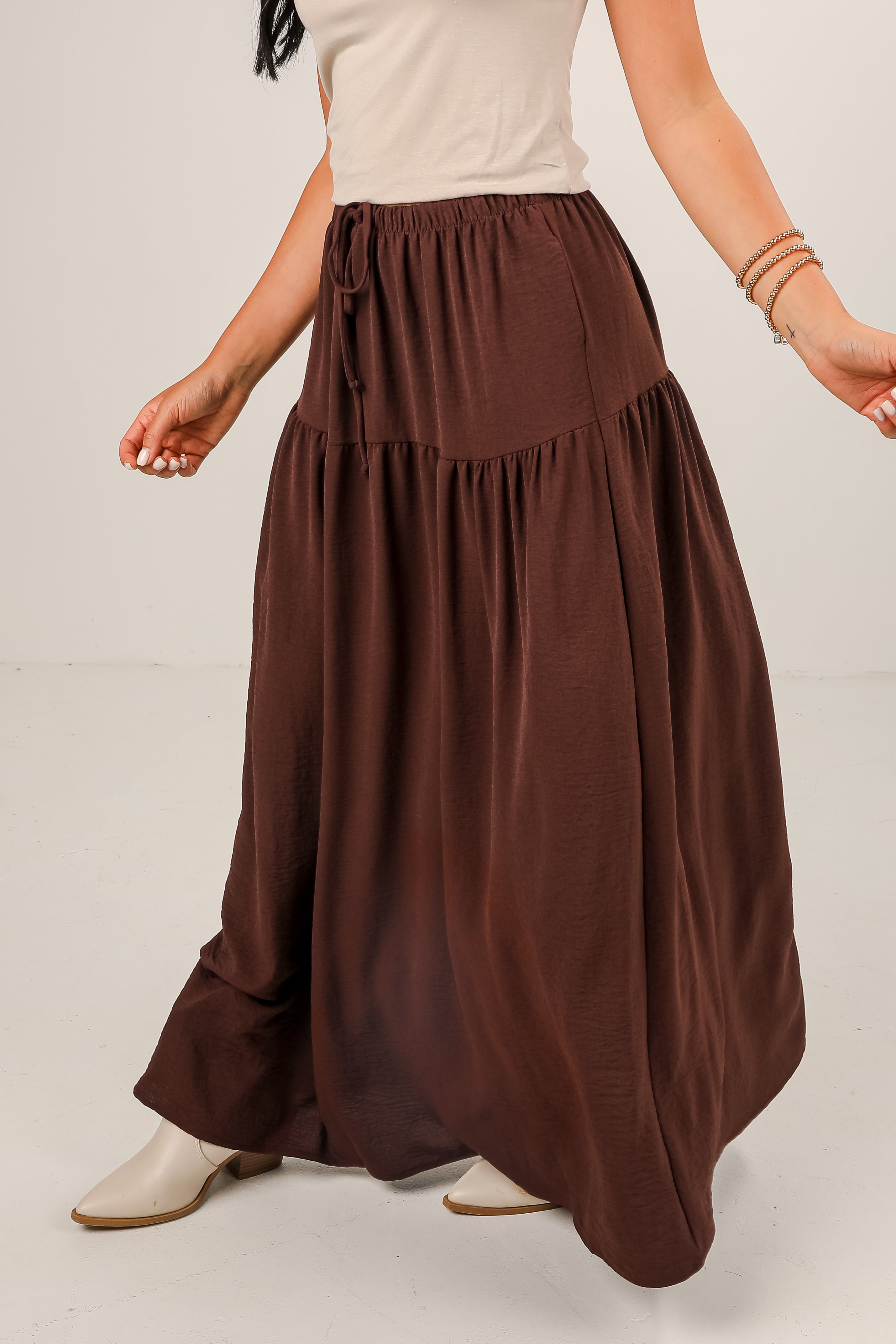 Brown long skirt worn by a person on a plain background