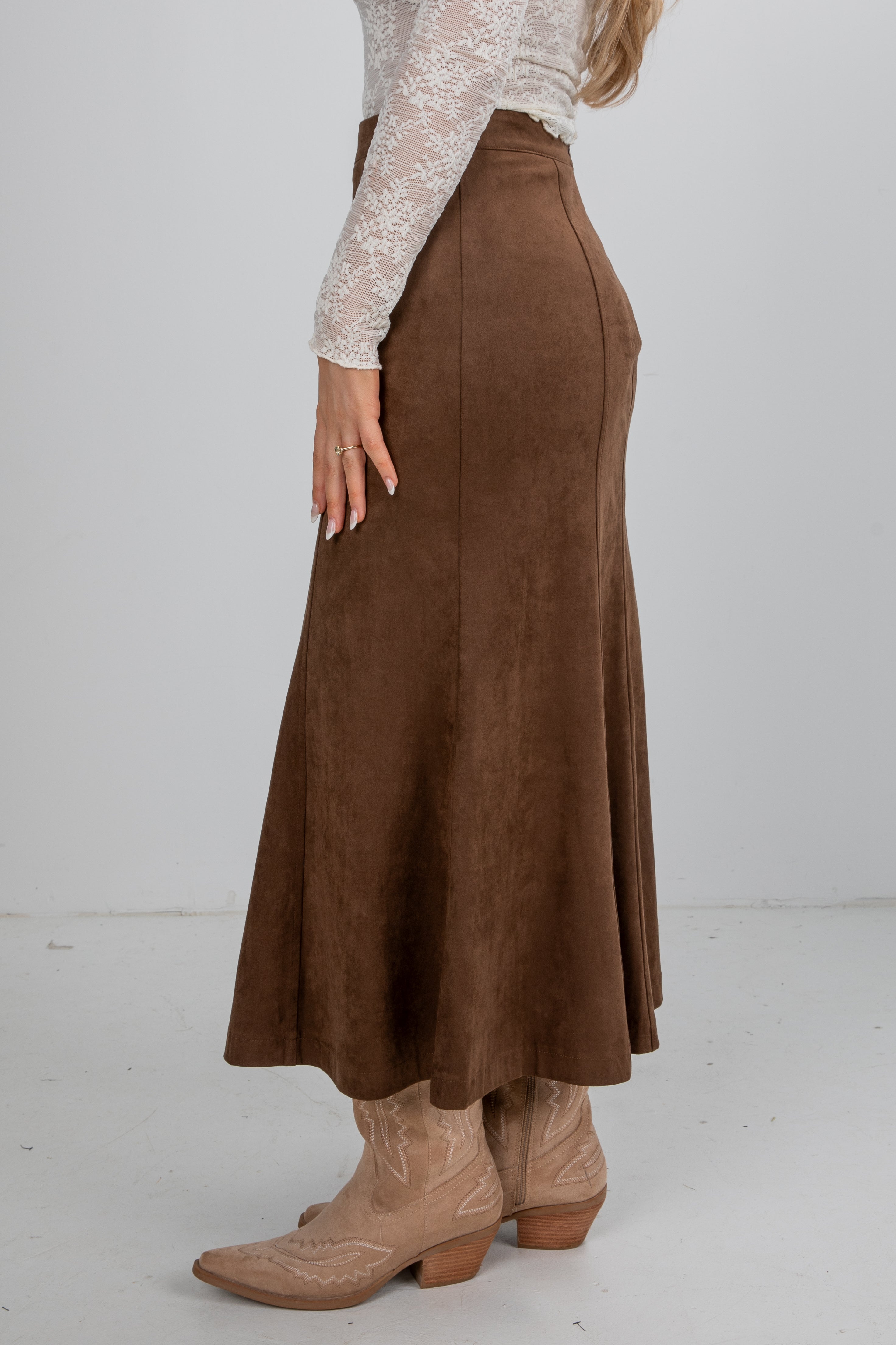 Brown suede skirt worn by a person on a white background