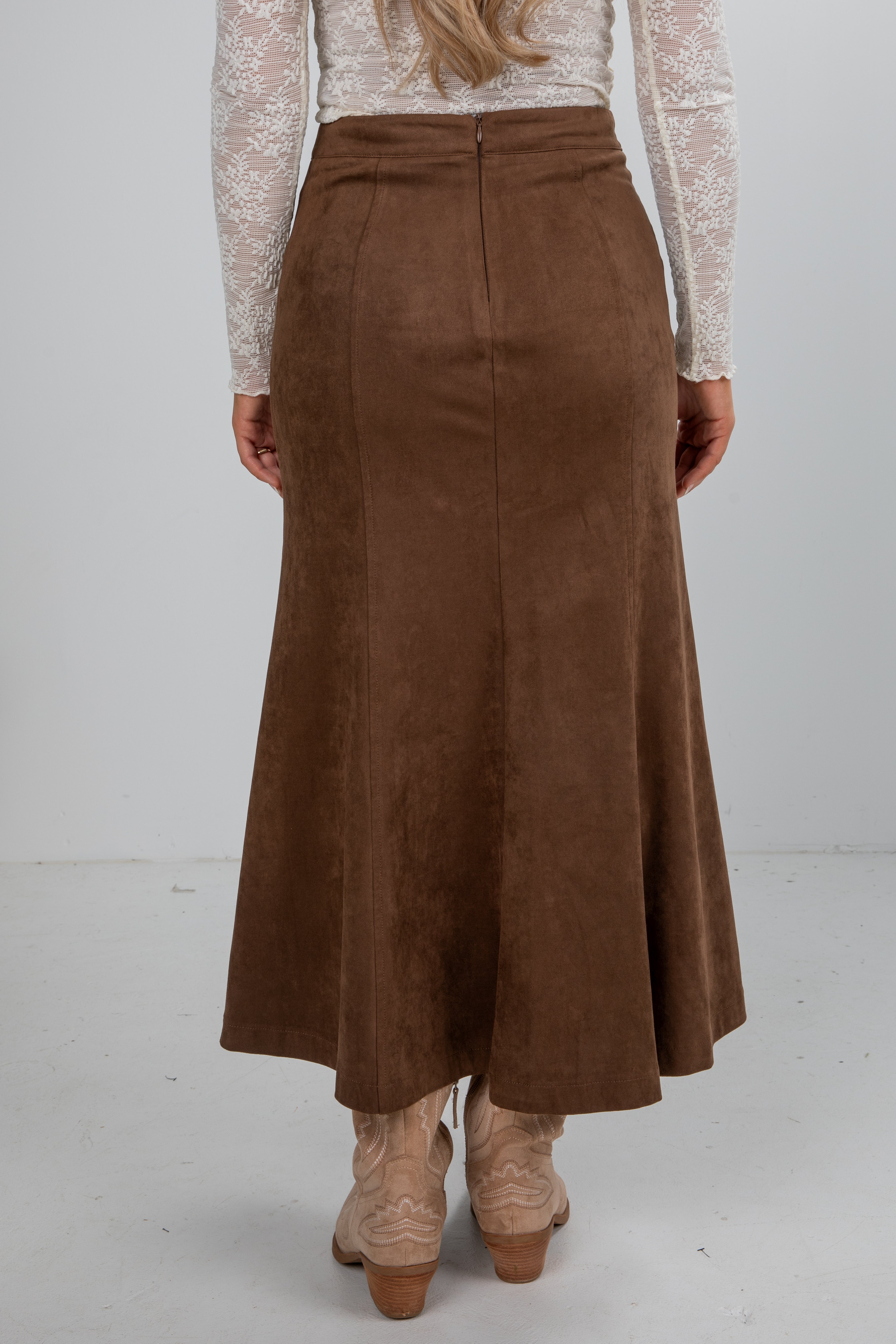 Brown suede skirt worn by a person on a white background