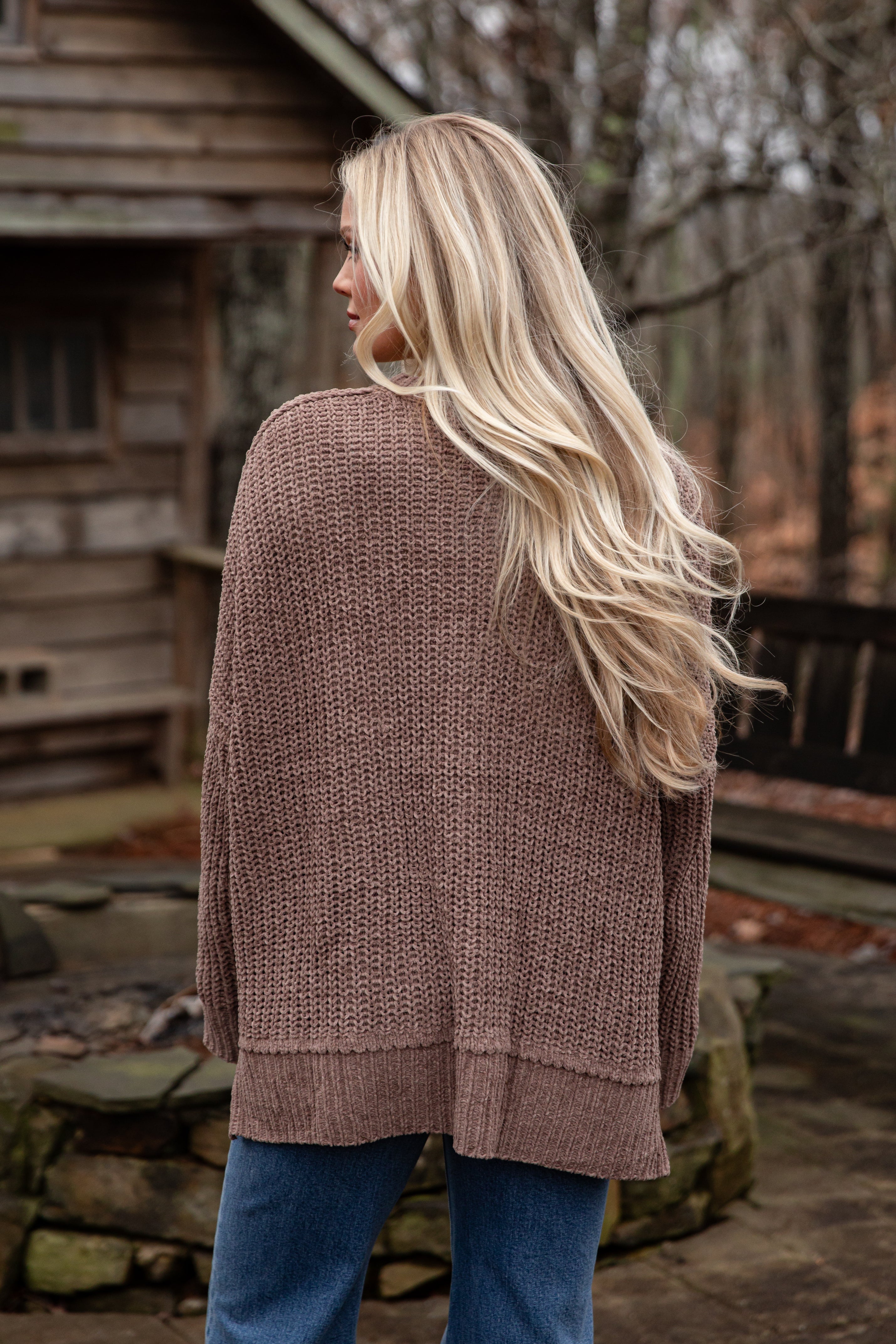 Woman wearing a brown knitted cardigan in an outdoor setting