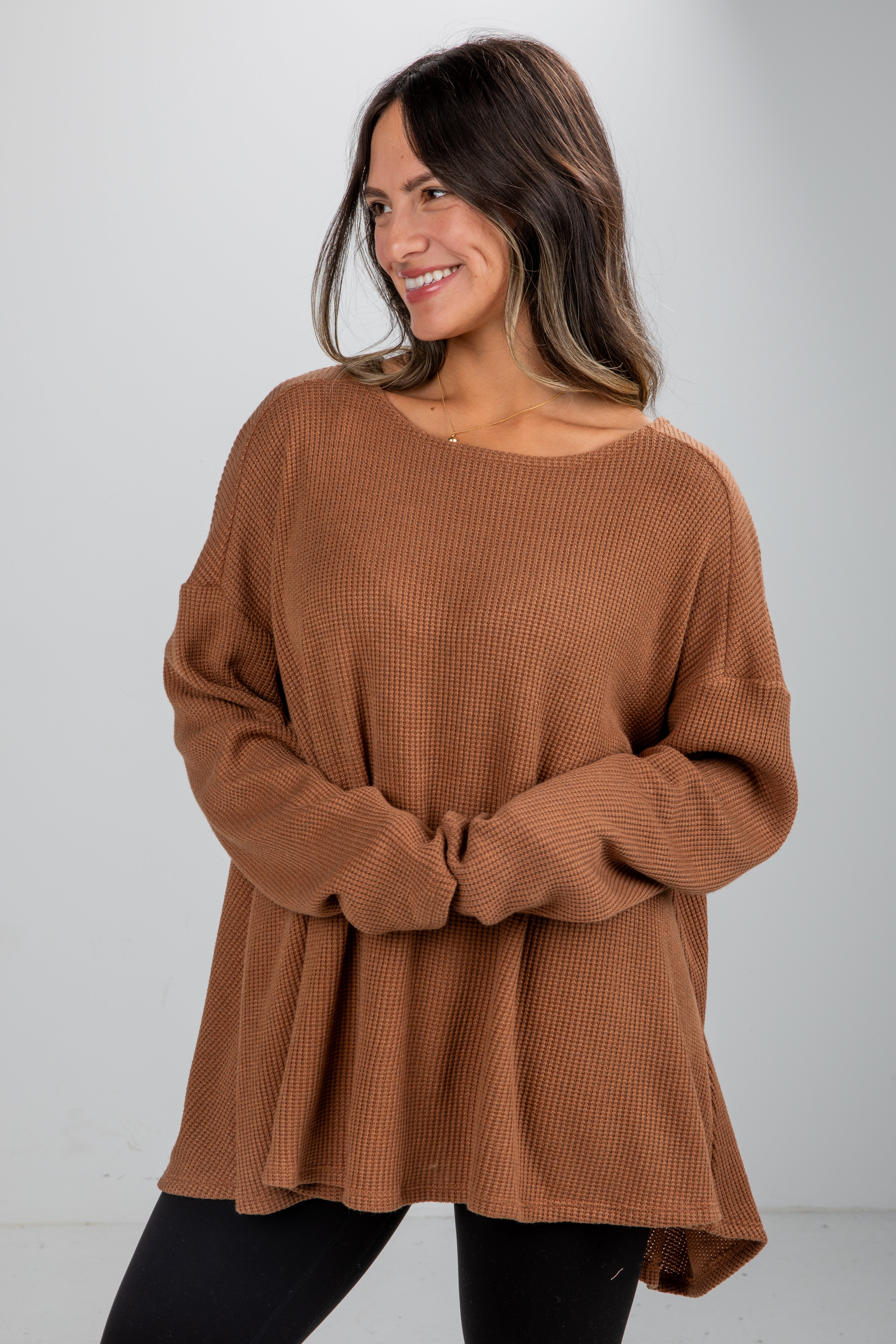 Woman wearing a brown sweater against a white background