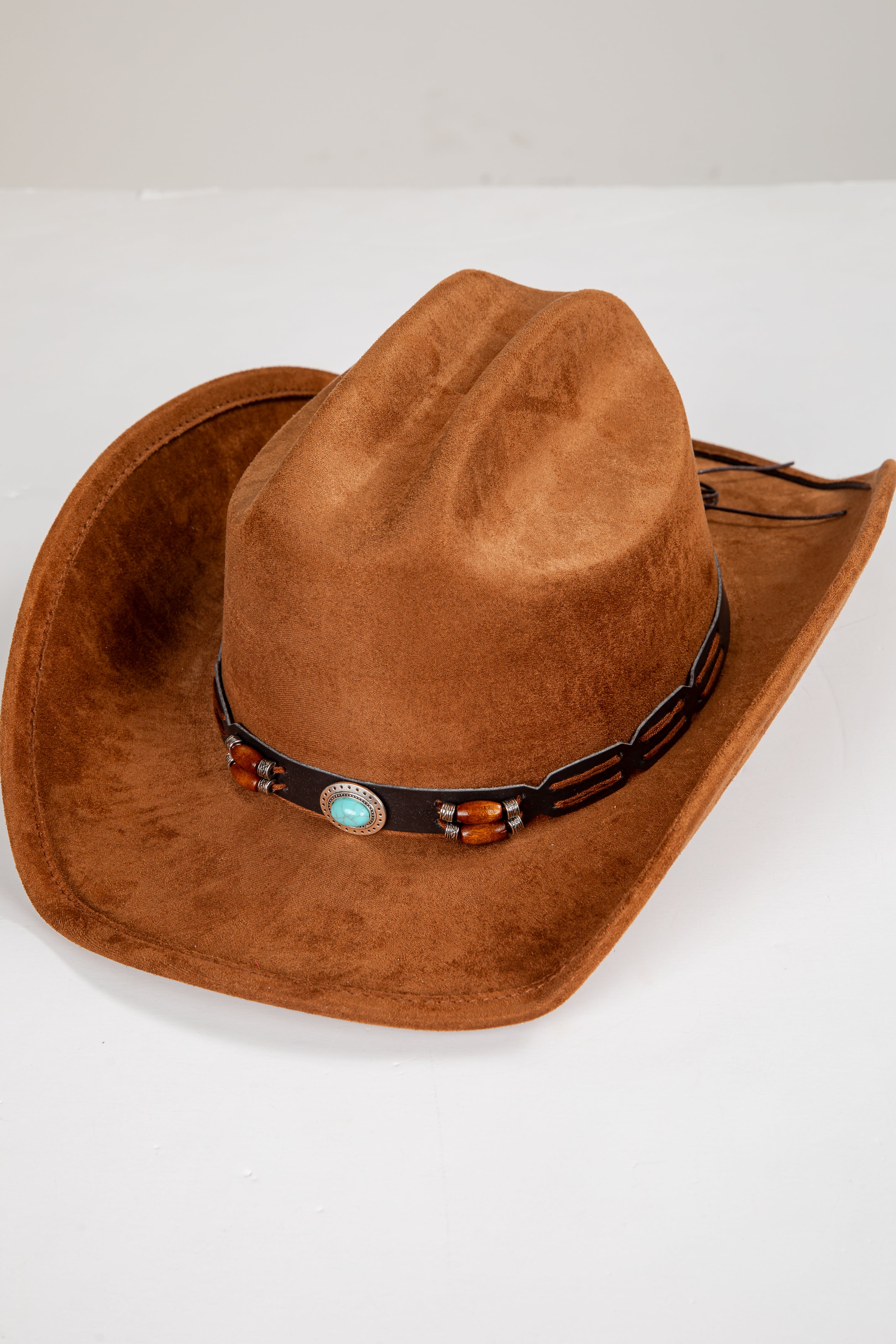 Brown cowboy hat with a decorative band on a white background
