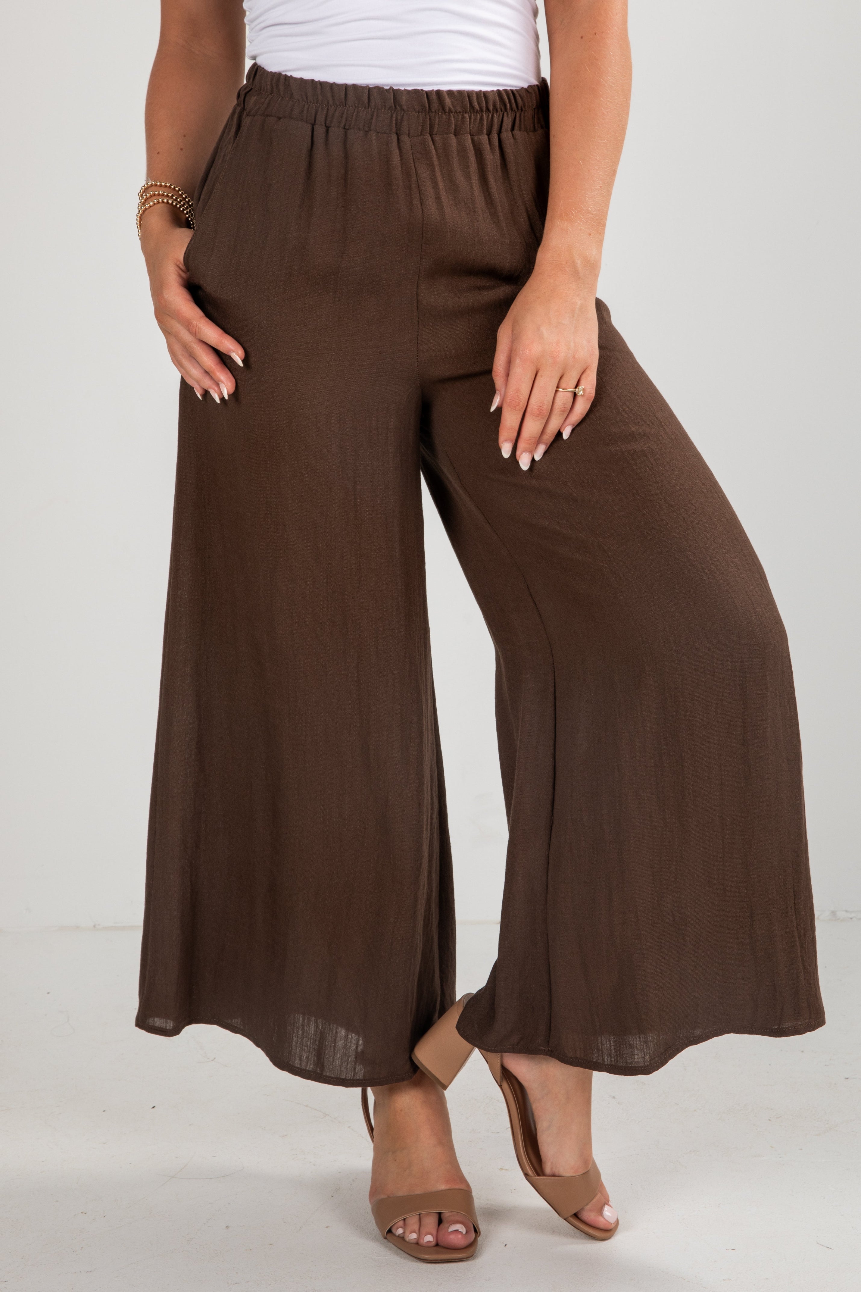 Brown wide-leg pants worn by a person on a white background
