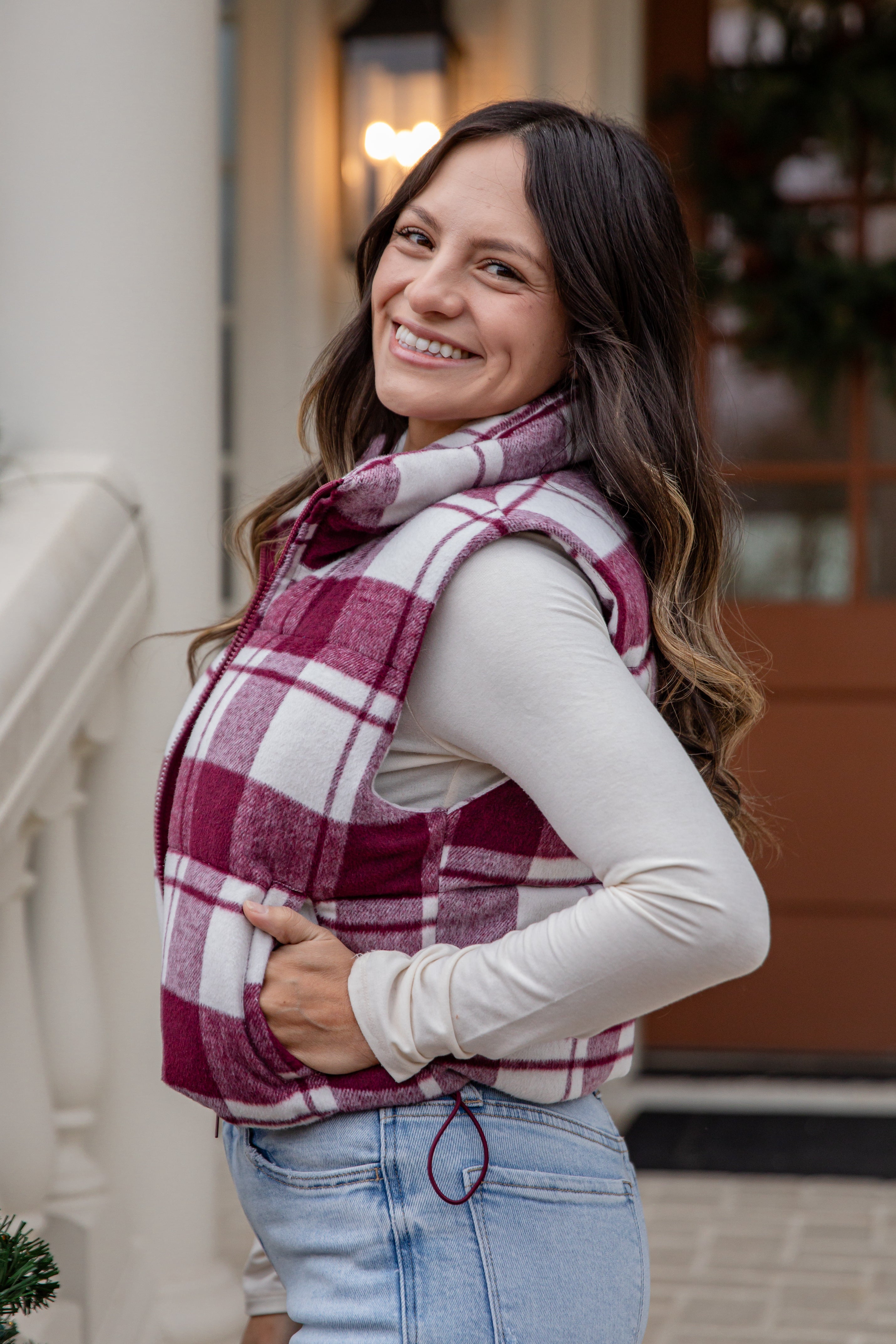 Woman wearing a plaid vest and scarf outdoors