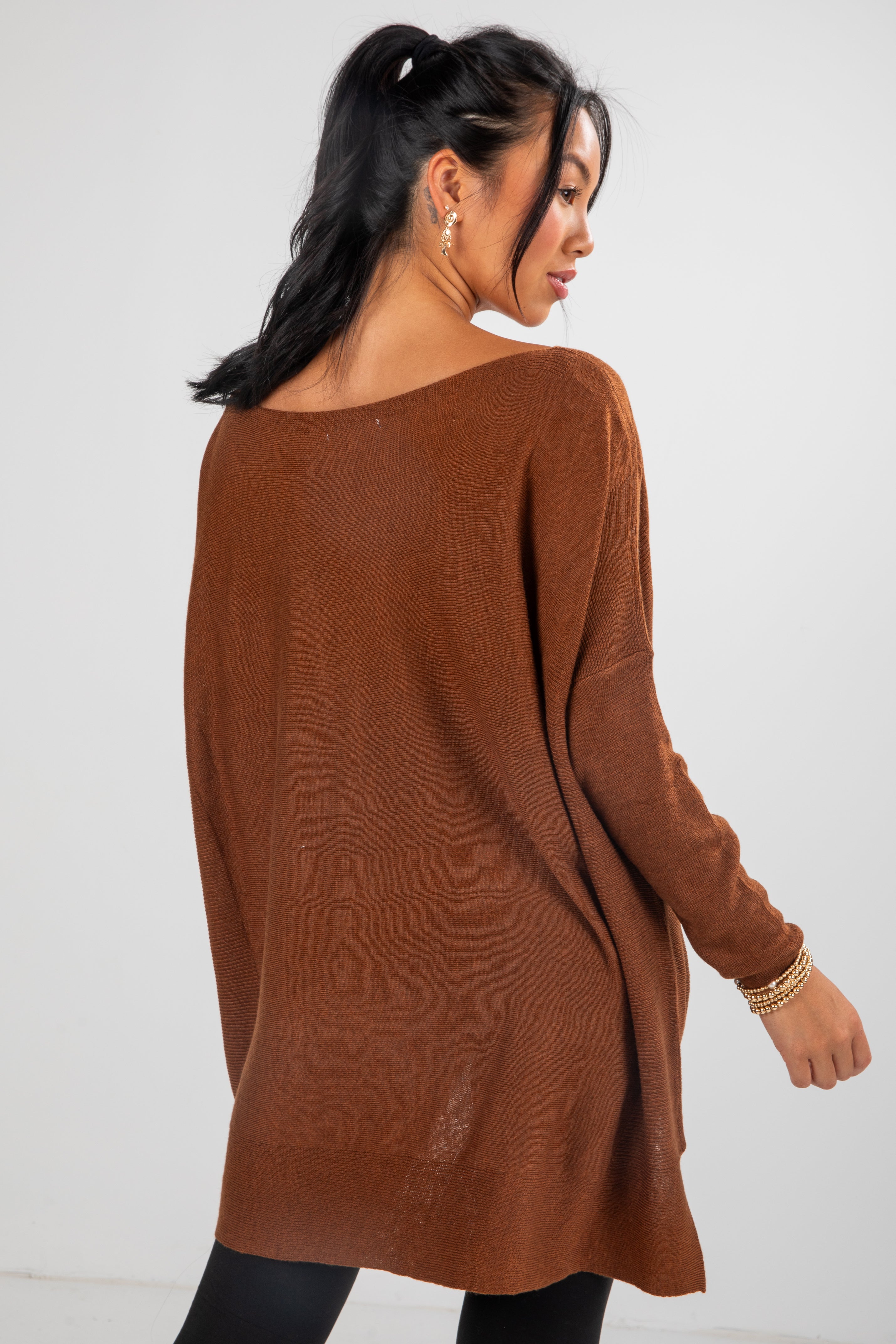 Woman wearing a brown sweater against a white background