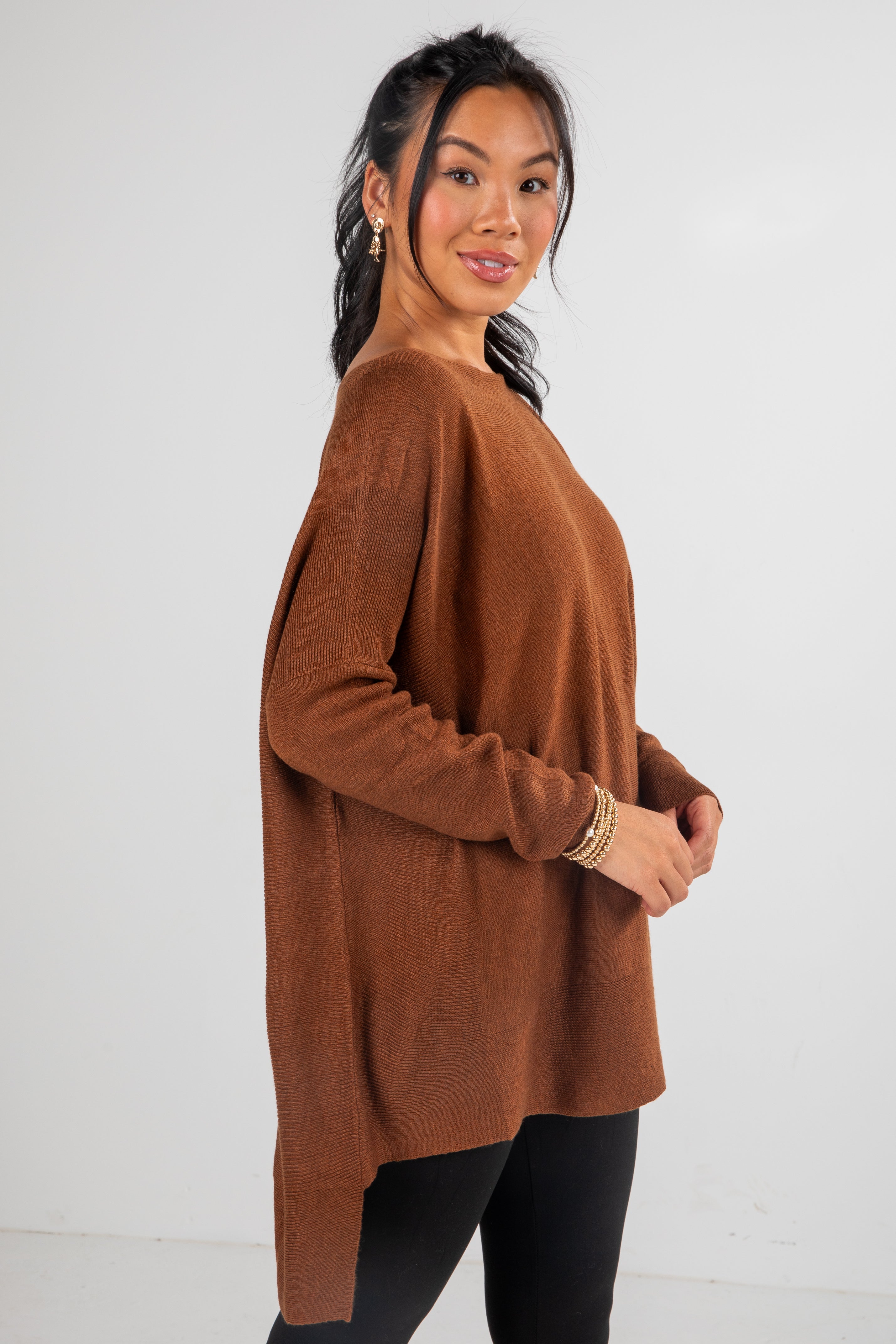Woman wearing a brown sweater against a white background
