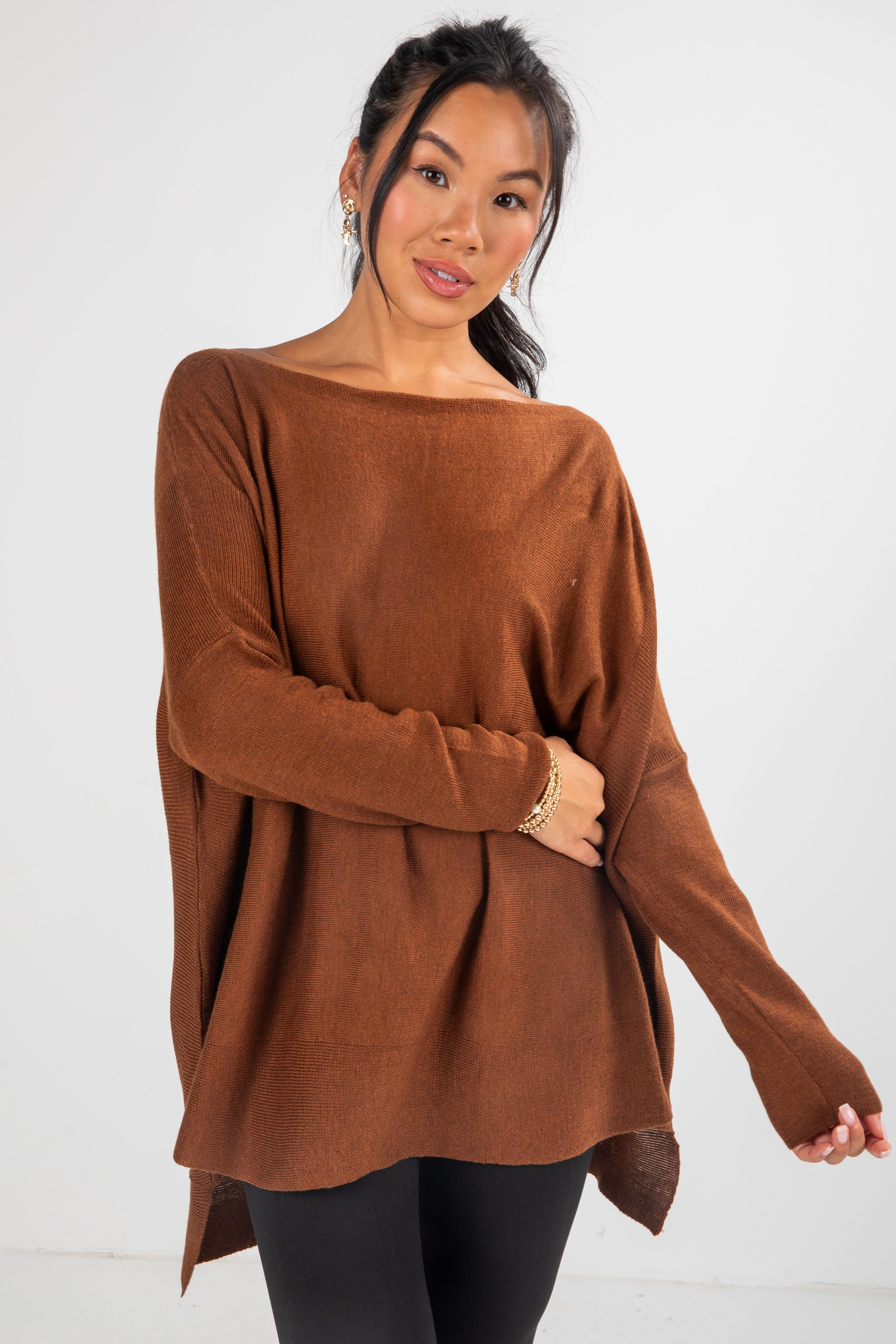 Woman wearing a brown sweater against a white background