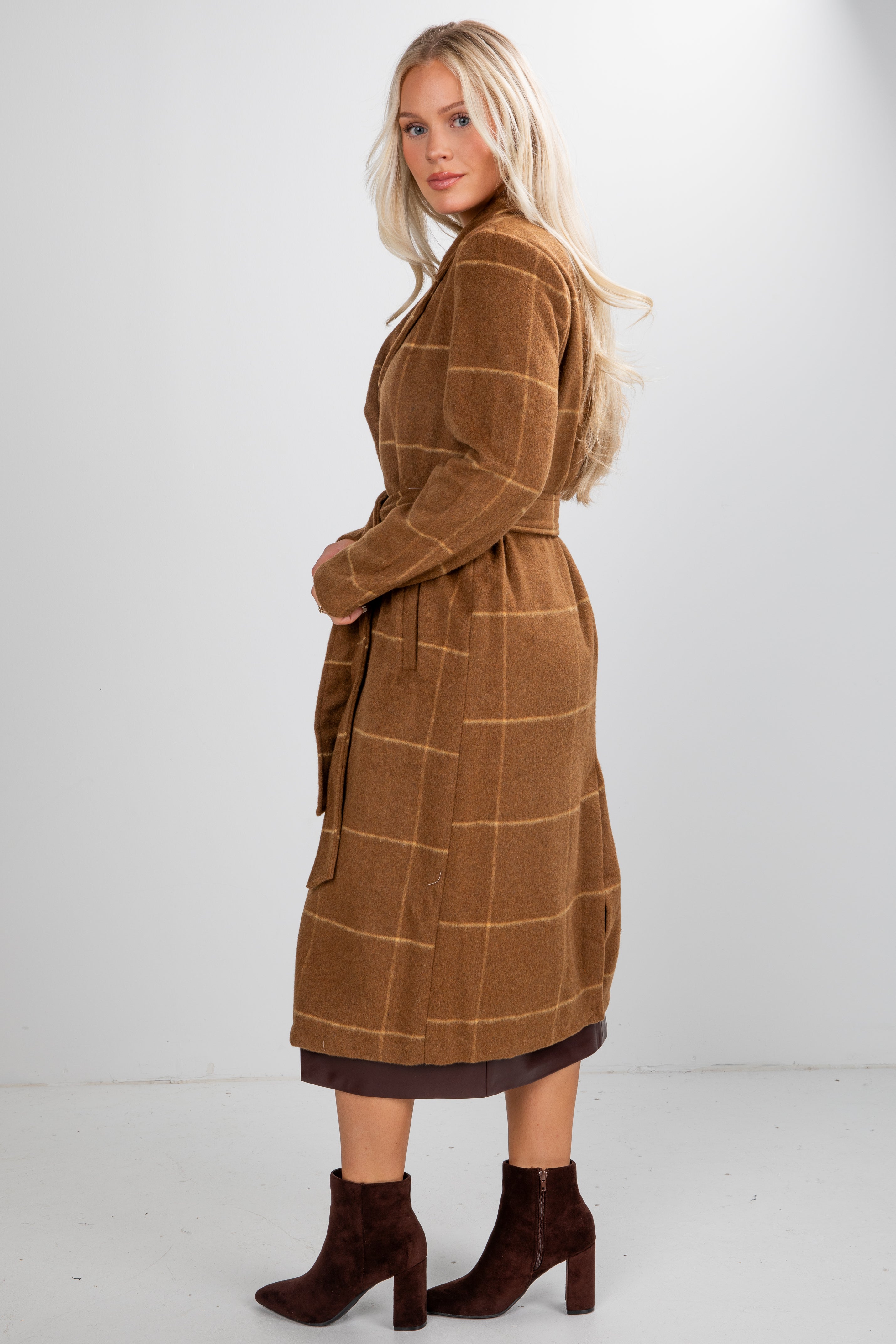 Woman wearing a brown checkered coat on a white background
