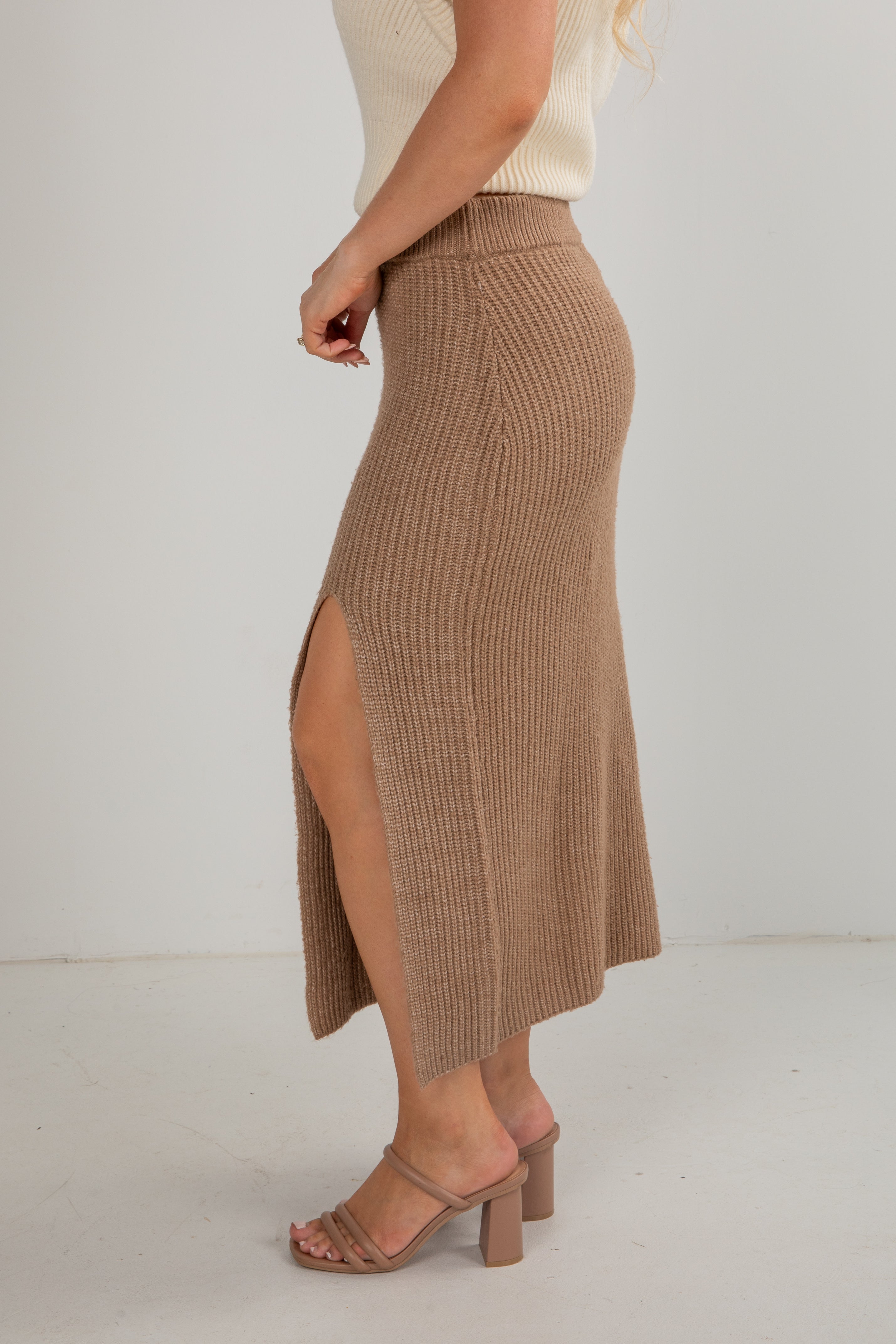 Brown ribbed skirt with a slit worn by a person on a white background