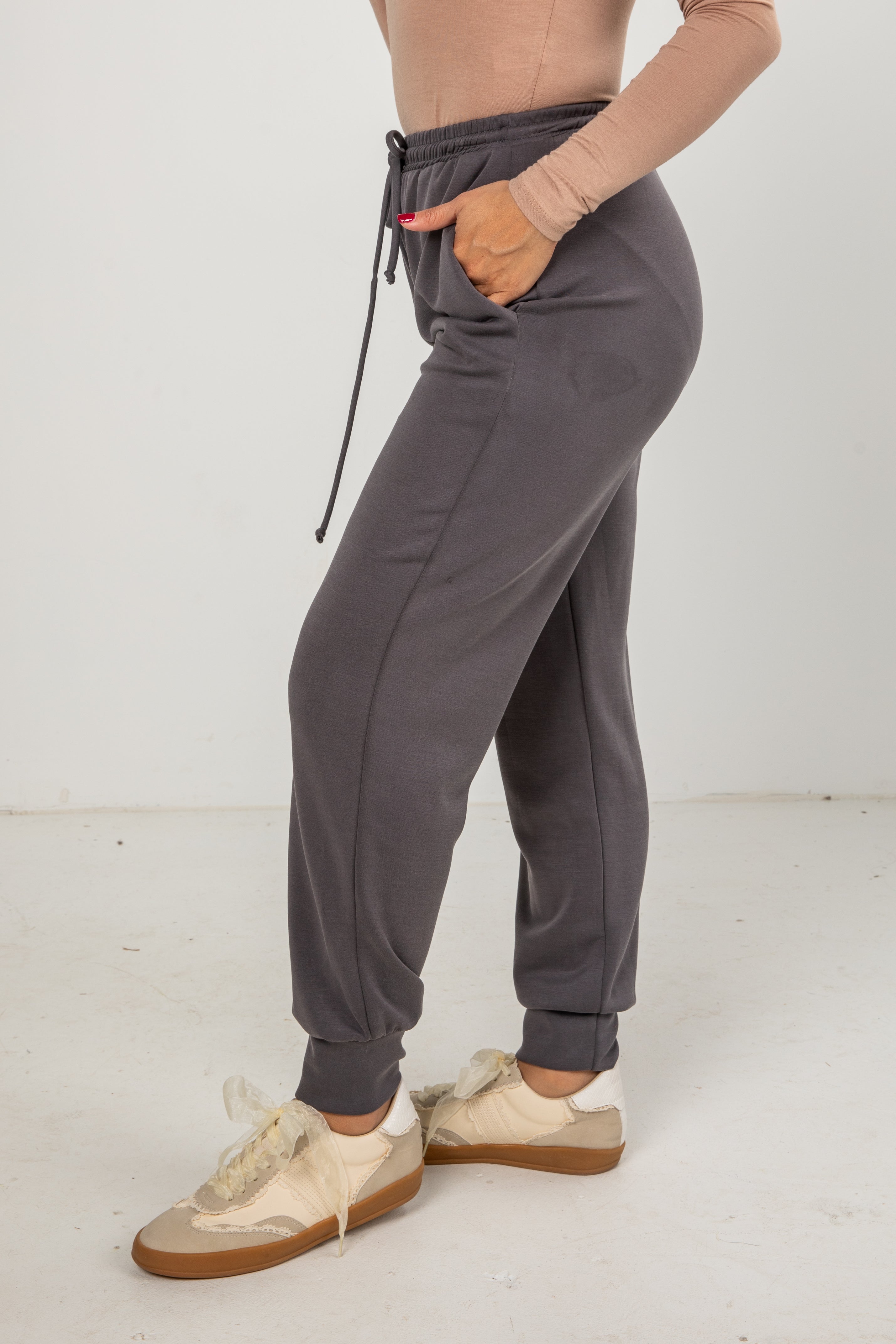 Person wearing gray sweatpants with a white background
