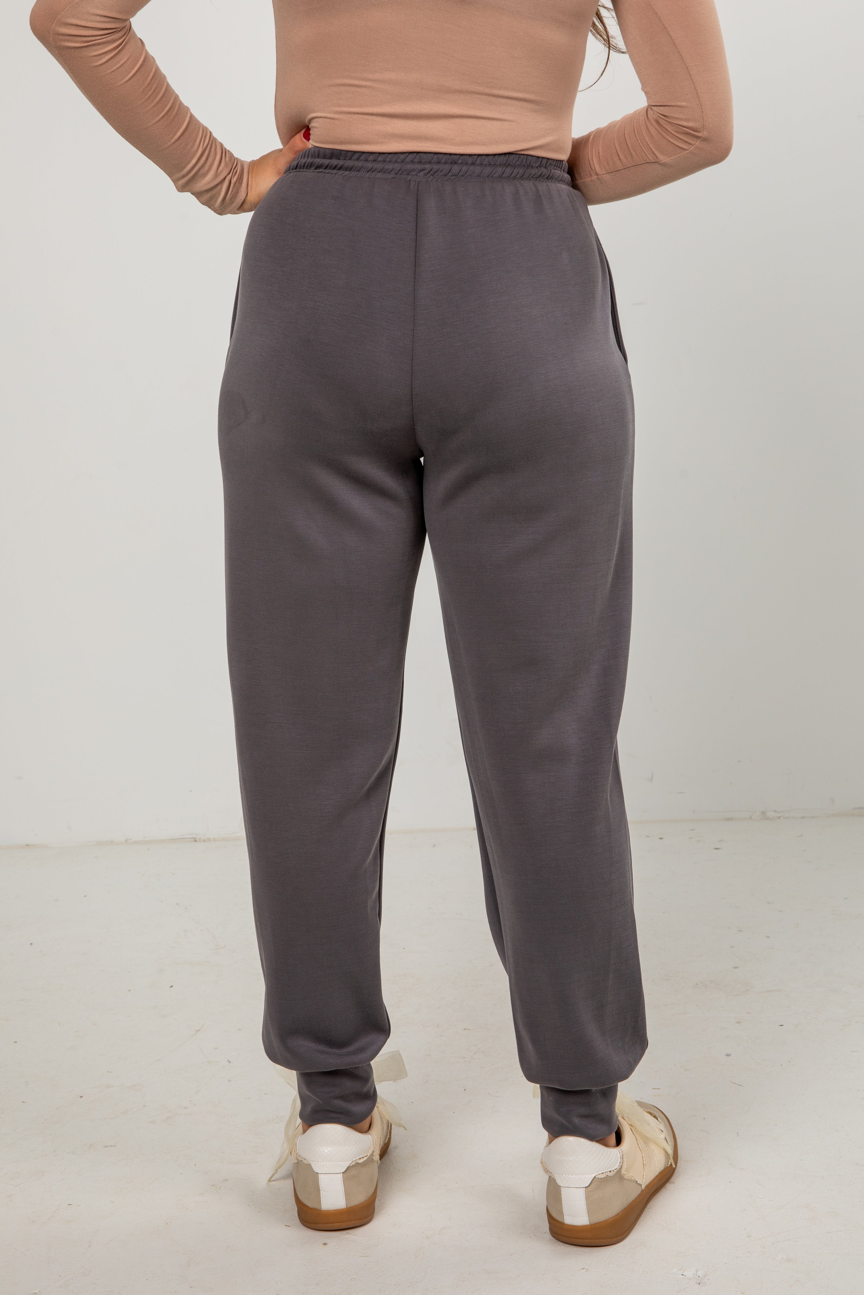 Person wearing gray sweatpants on a white background