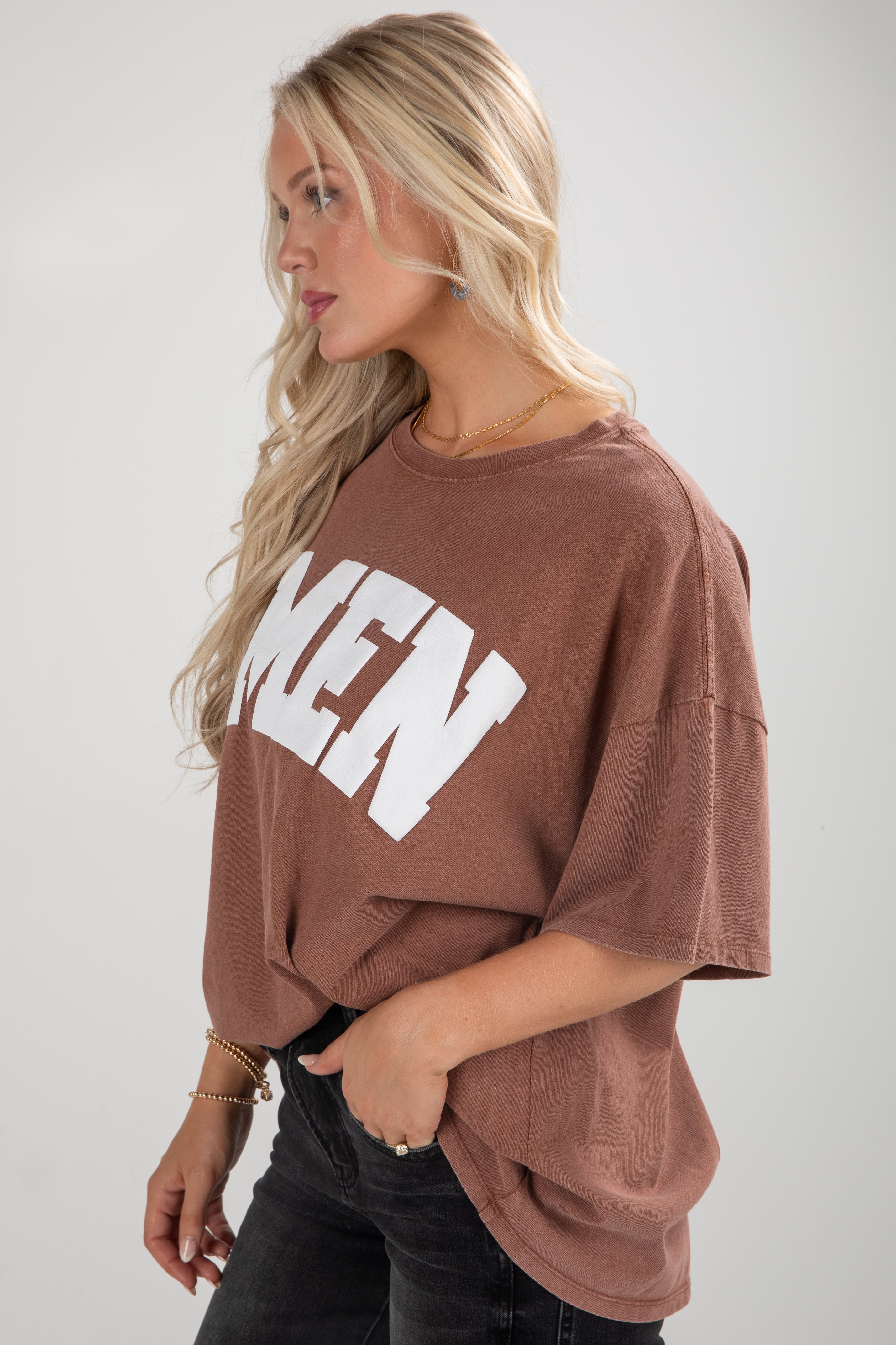 Woman wearing a brown oversized t-shirt with &