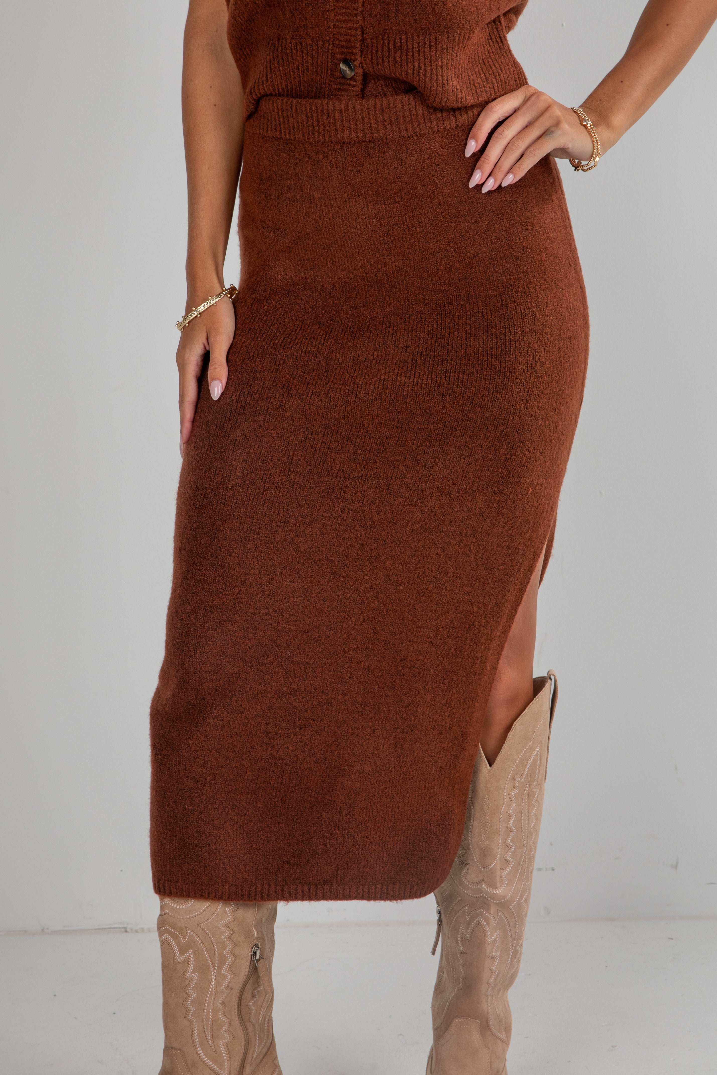 Brown knit dress with a slit on a plain background