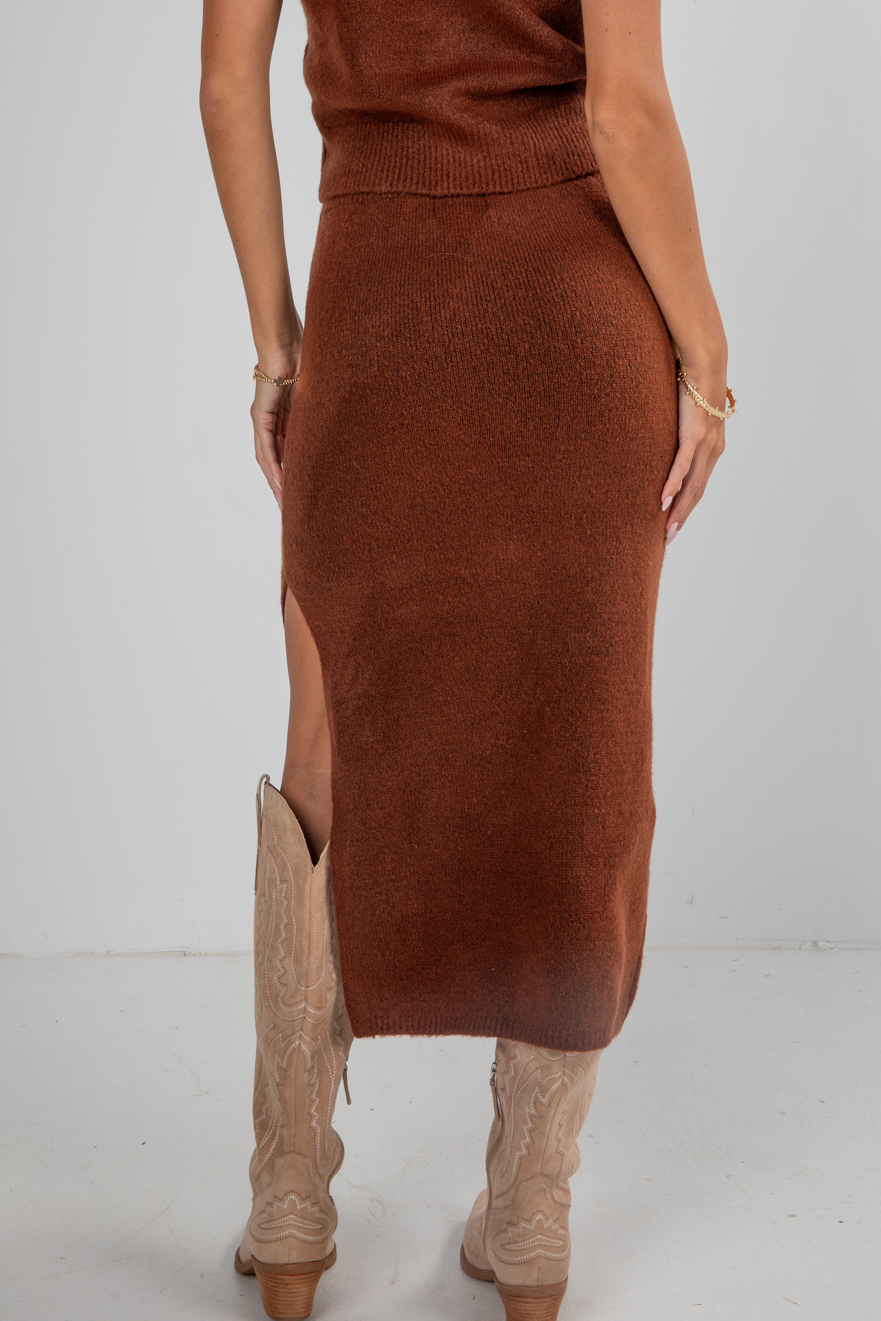 Brown knit skirt worn by a person on a white background