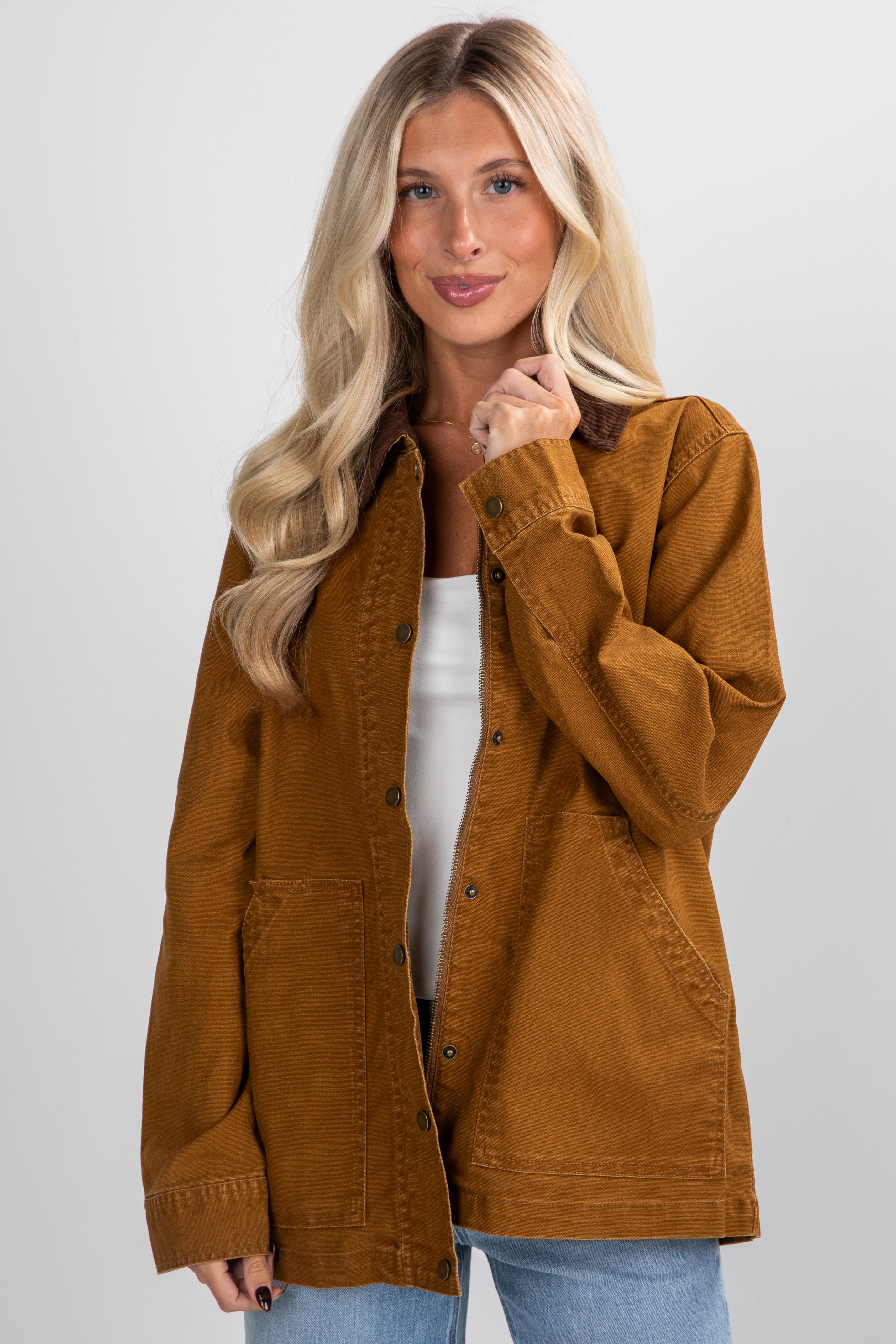 Woman wearing a brown jacket on a plain background