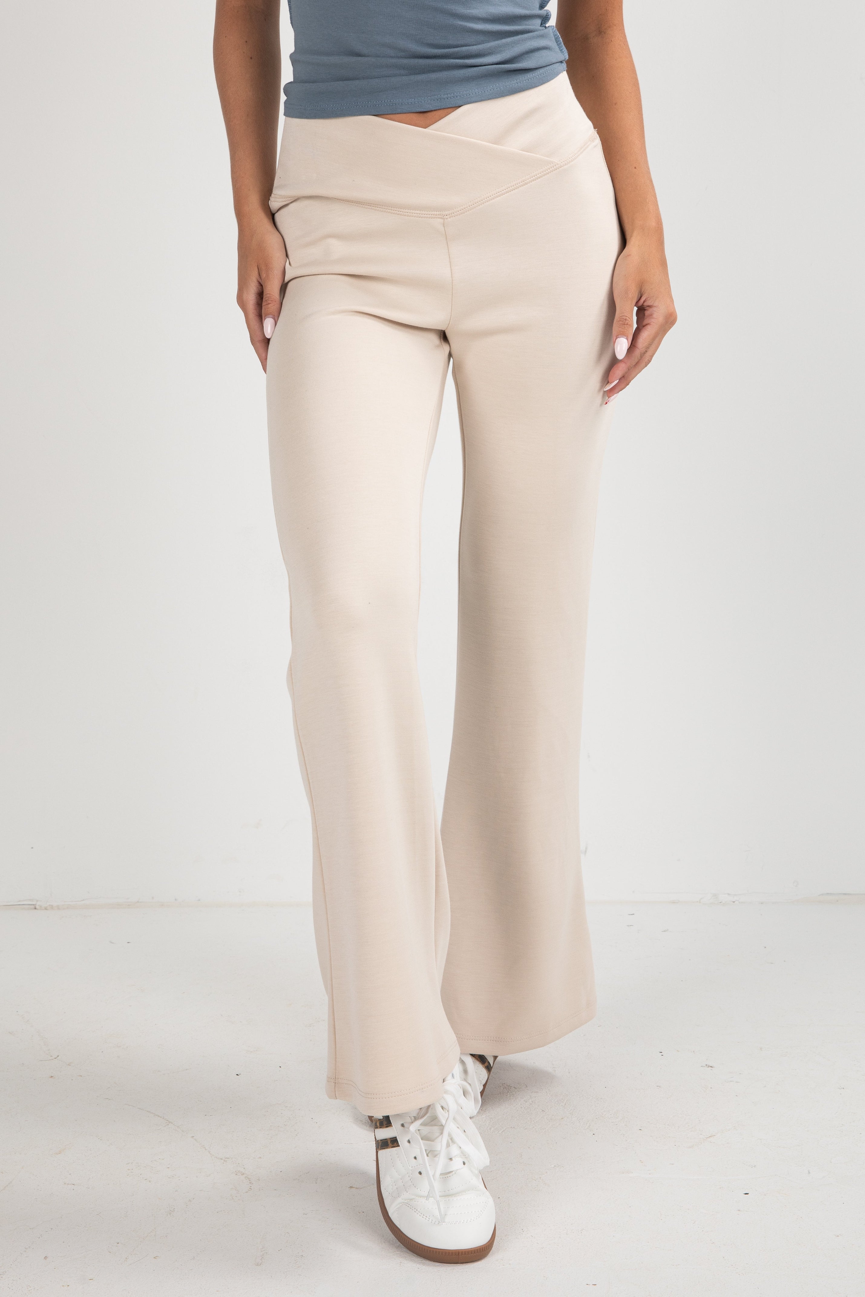 Beige pants worn by a person on a white background