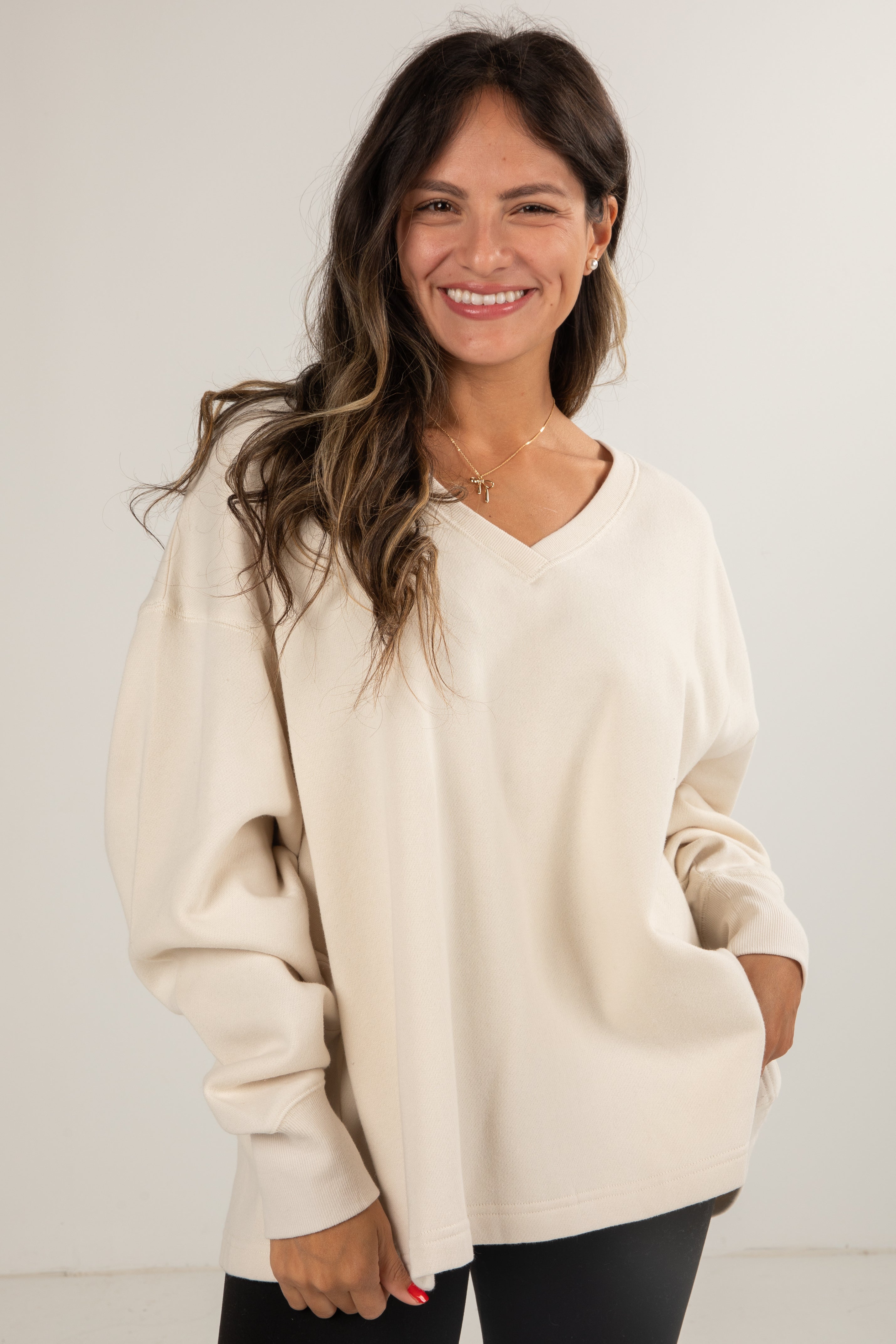 Woman wearing a beige sweater against a white background