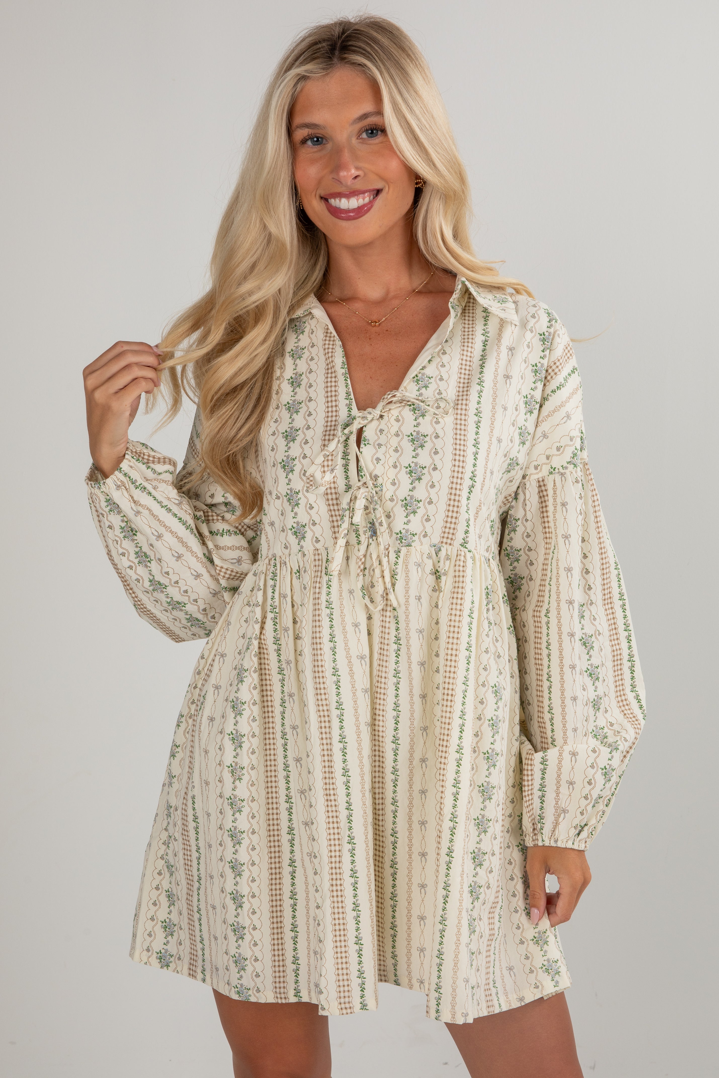 Woman wearing a patterned dress against a plain background