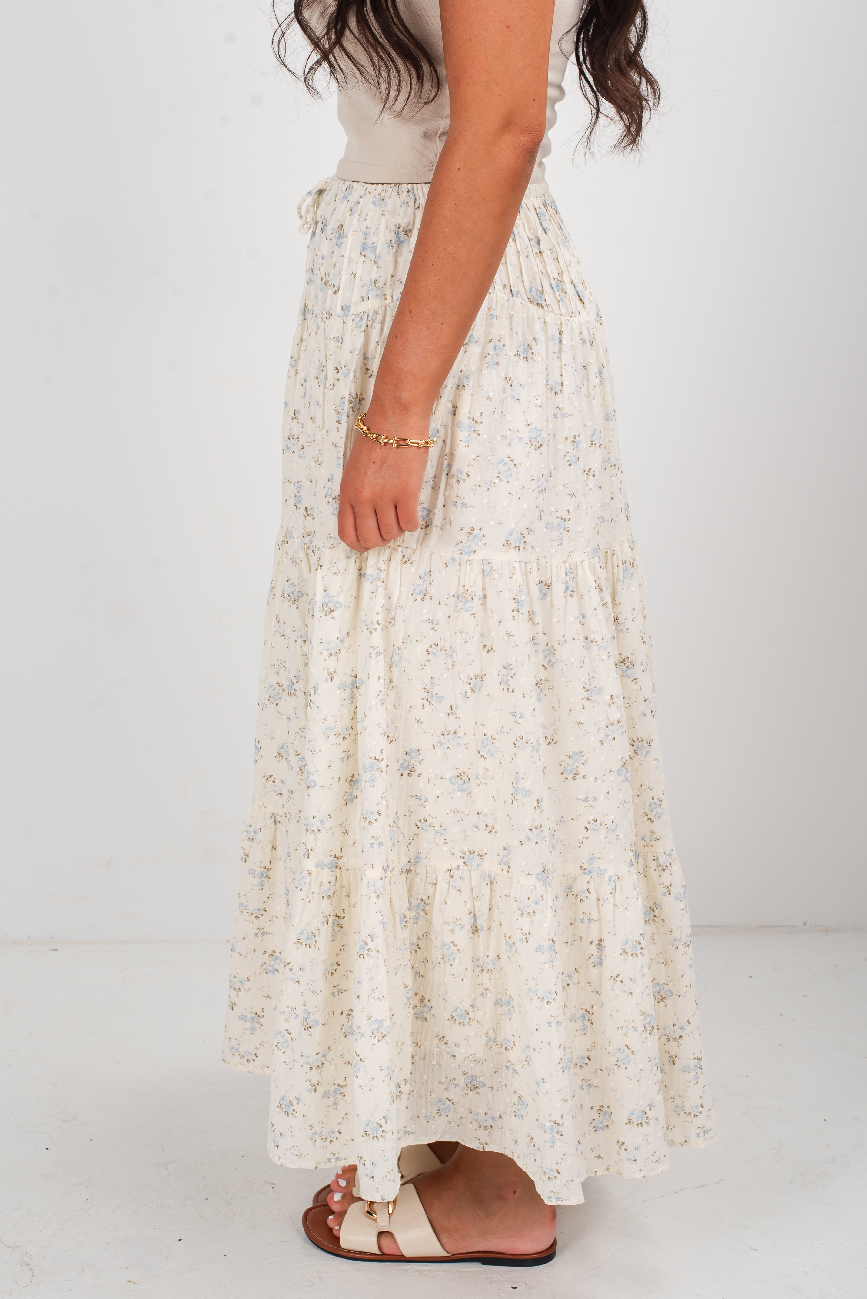 Long floral skirt worn by a person on a white background