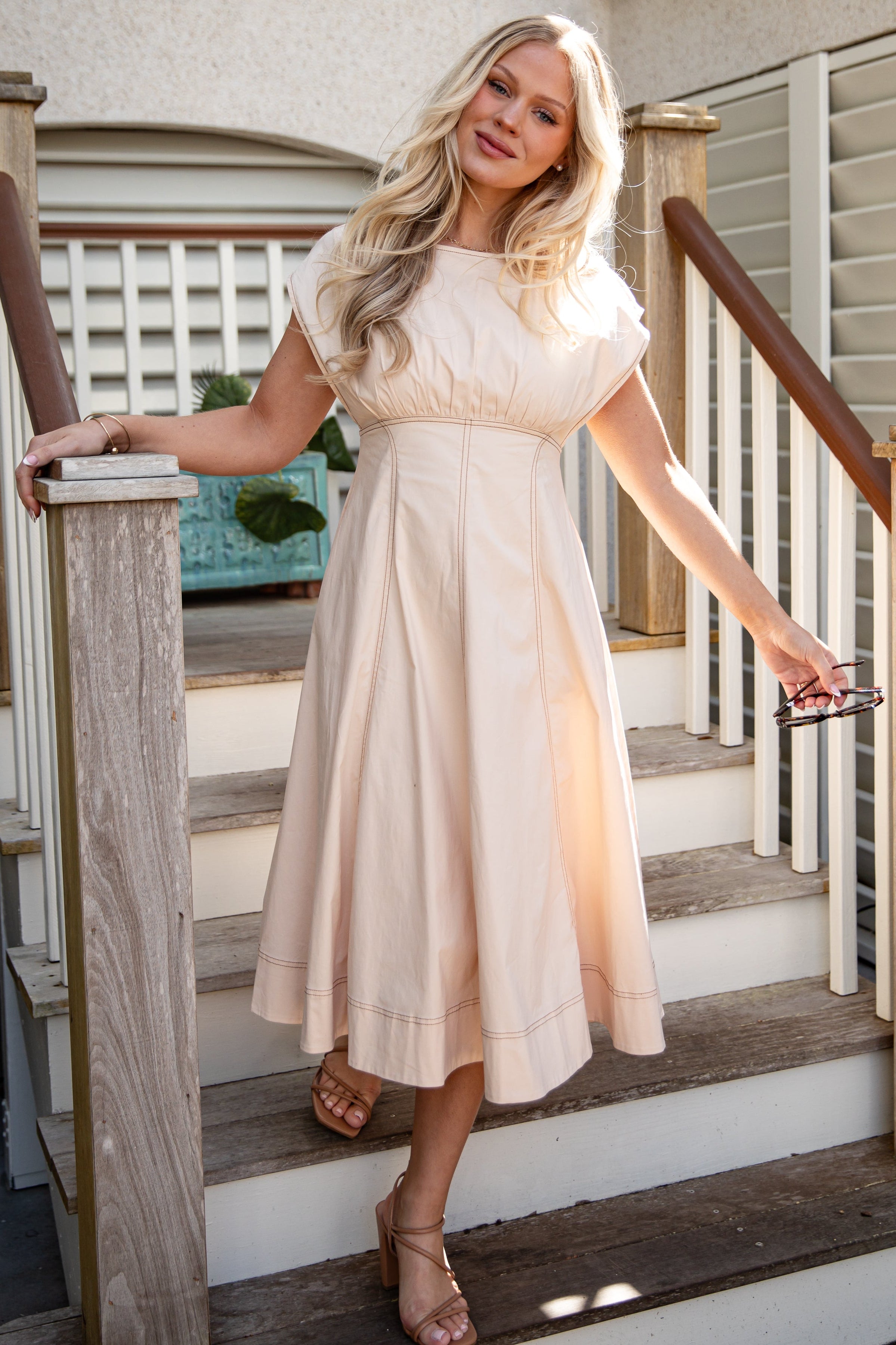 Woman in a white dress standing on a staircase