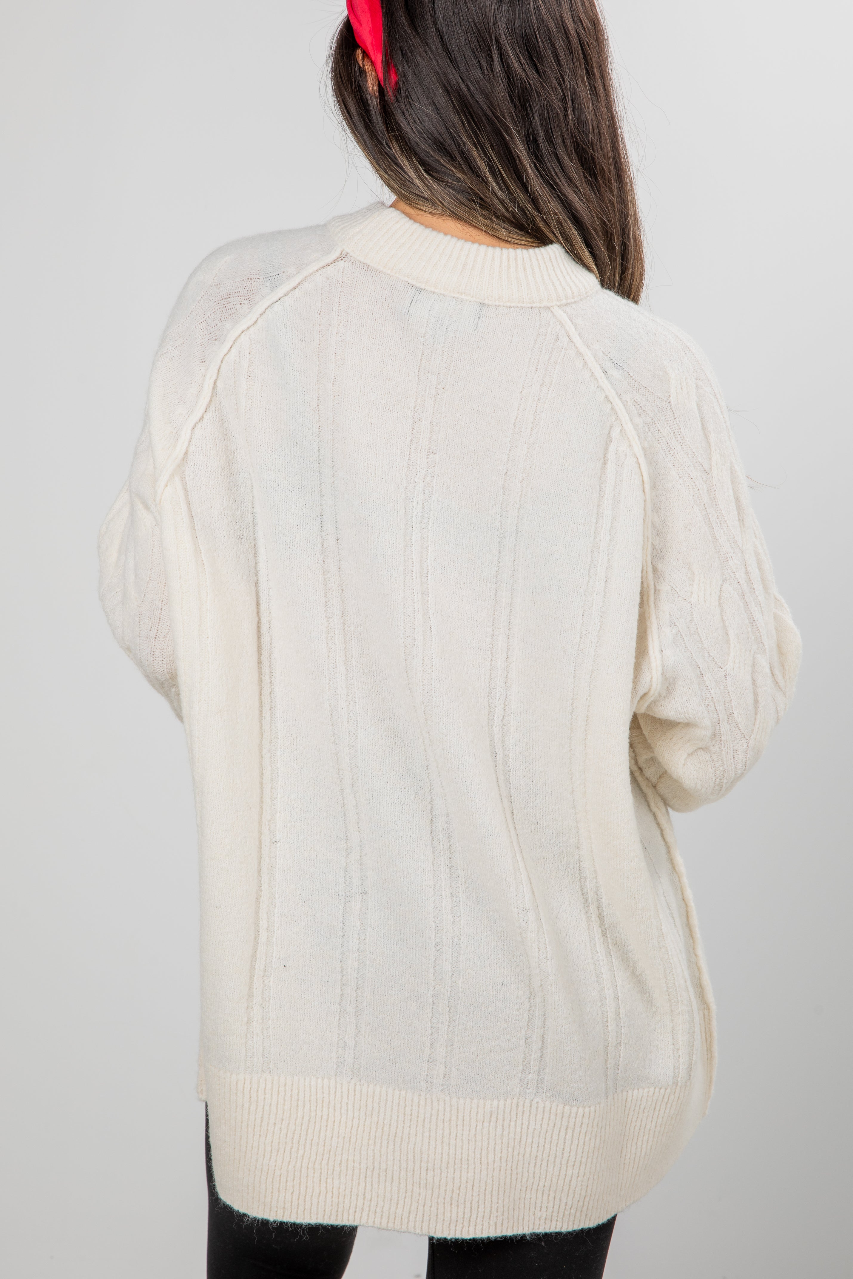 Beige sweater worn by a person against a plain background