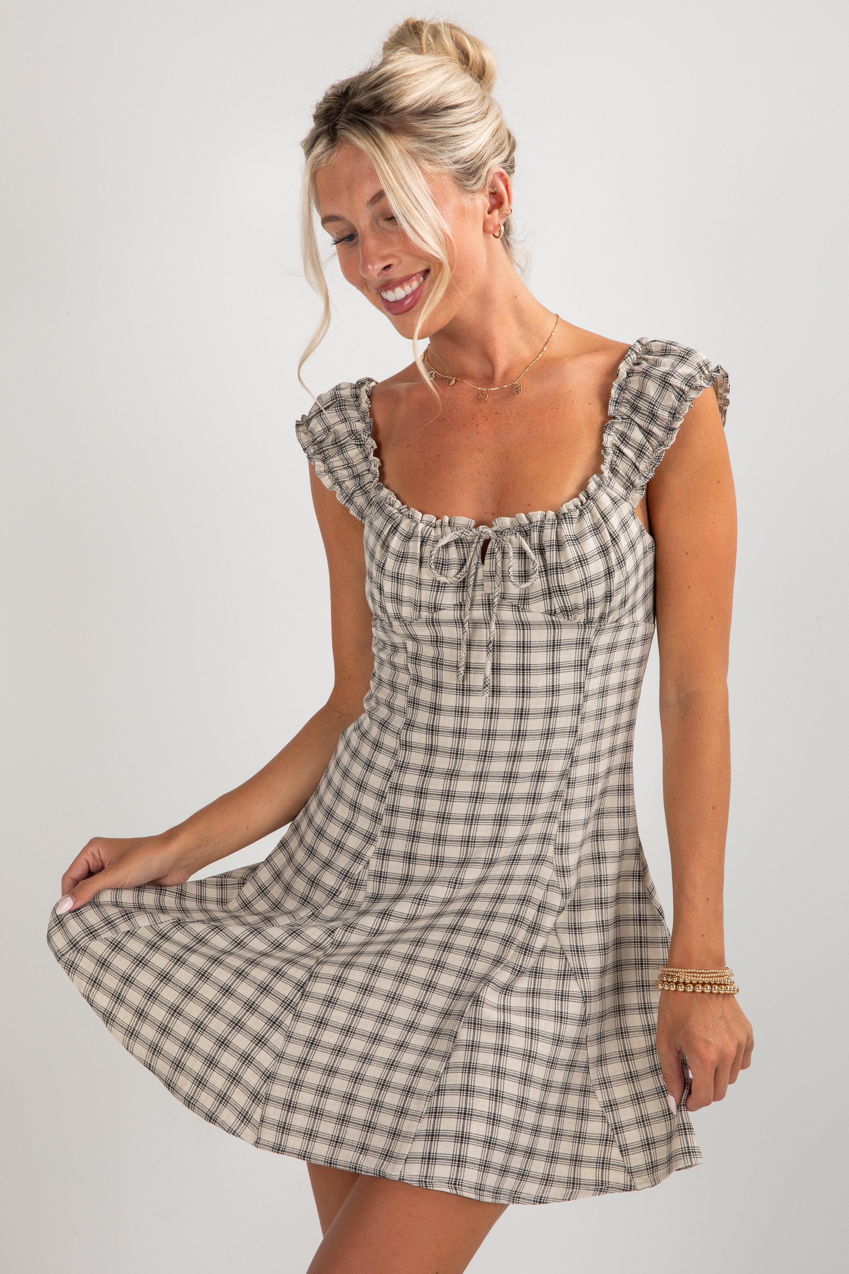 Woman wearing a checkered dress on a plain background