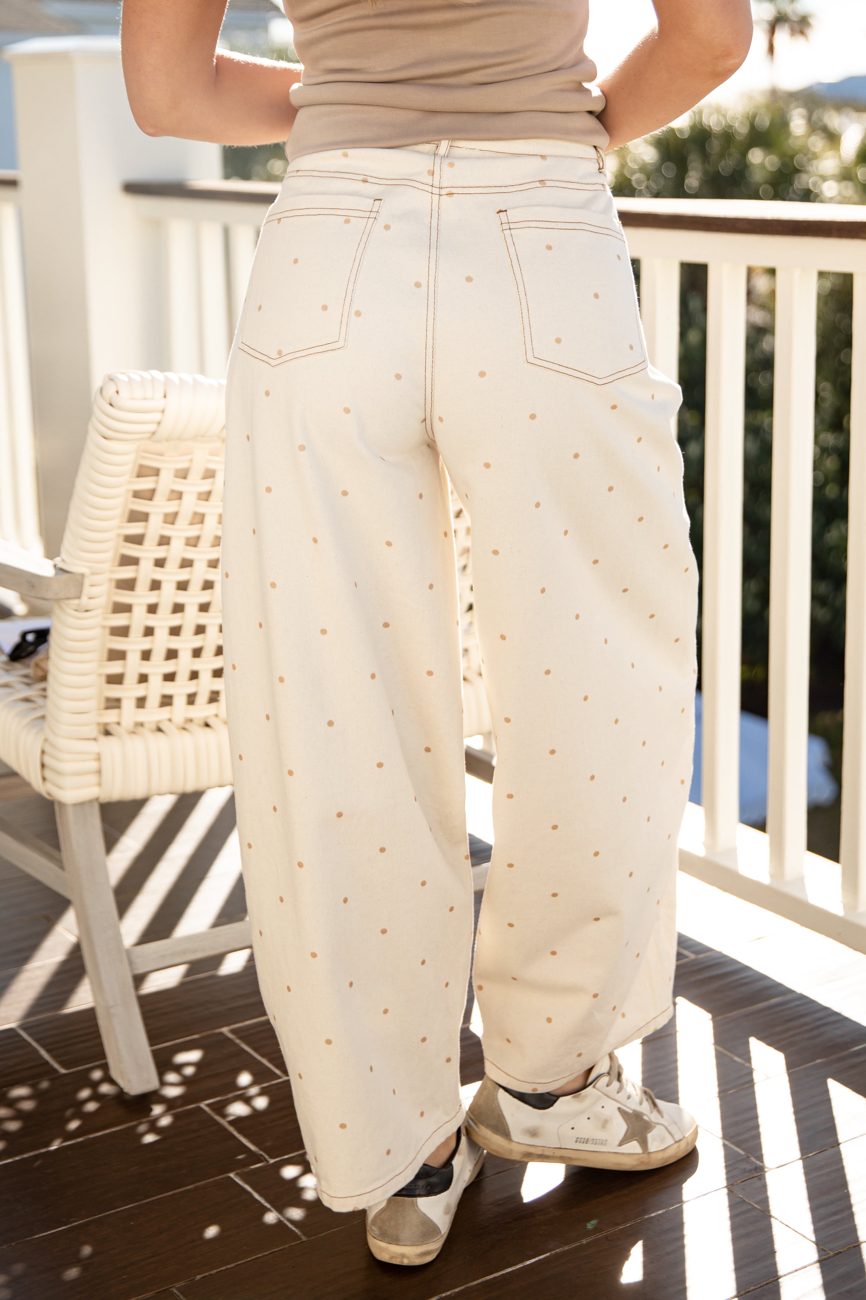 Person wearing cream-colored pants on a balcony