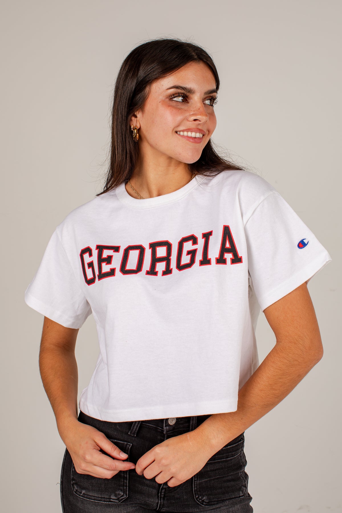 A woman wearing a white cropped t-shirt with &