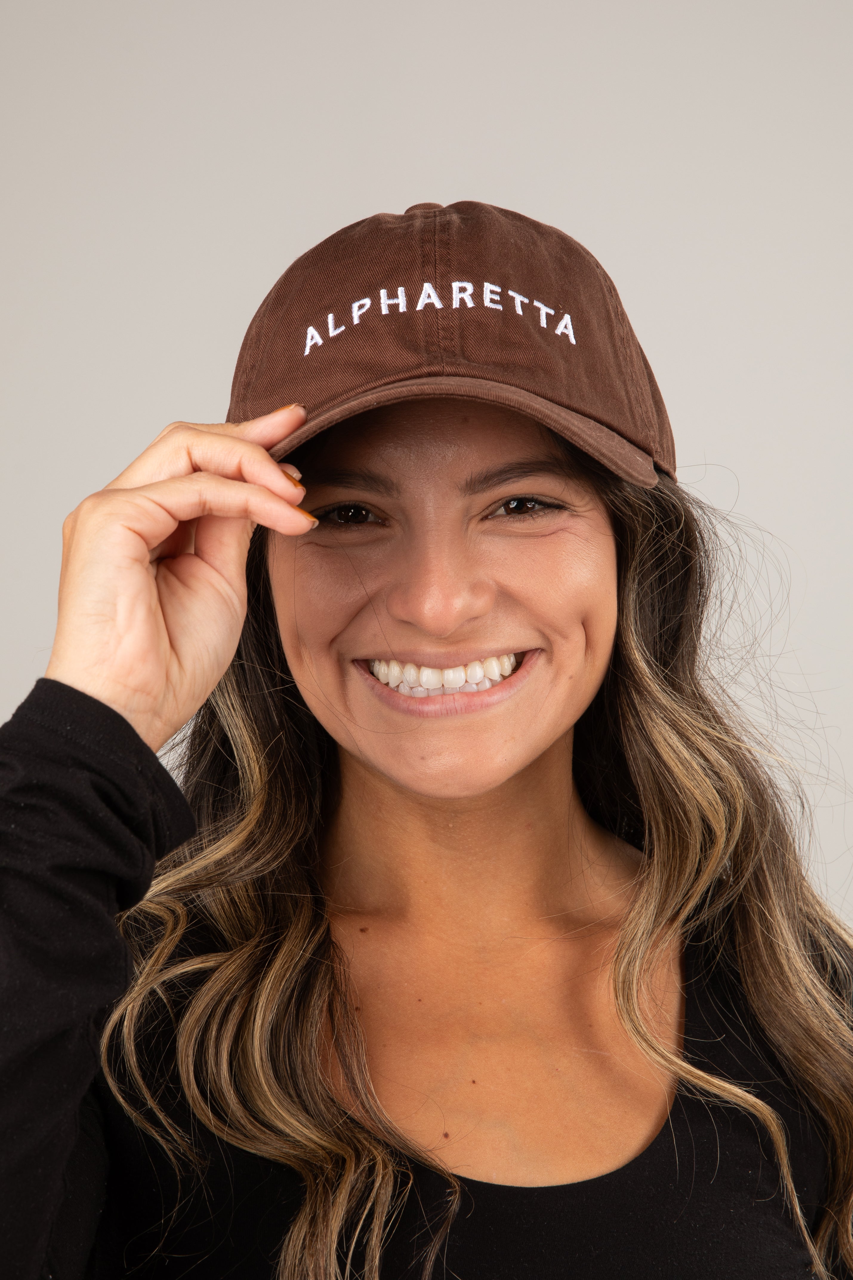 Person wearing a brown cap with &