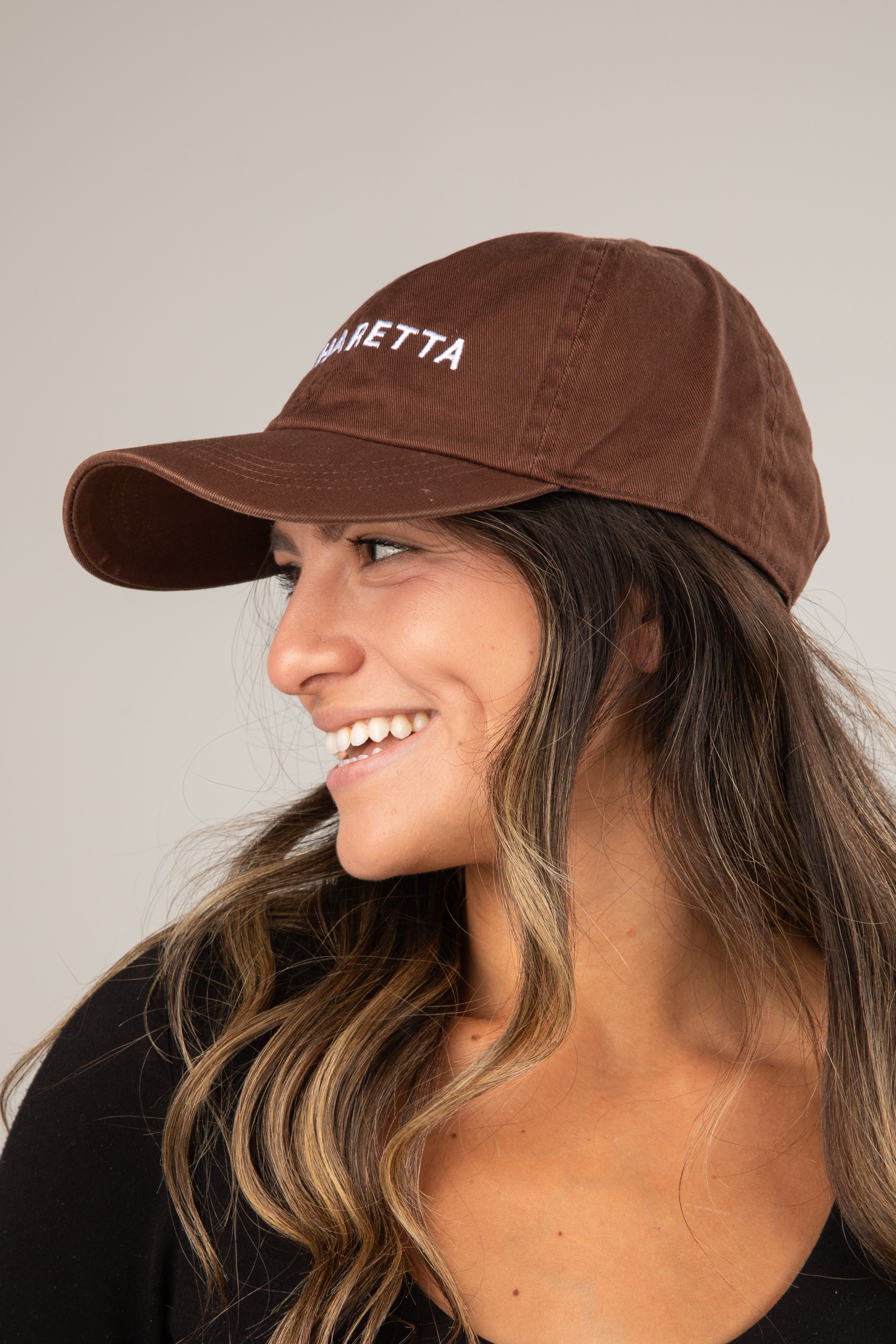 Woman wearing a brown cap with &