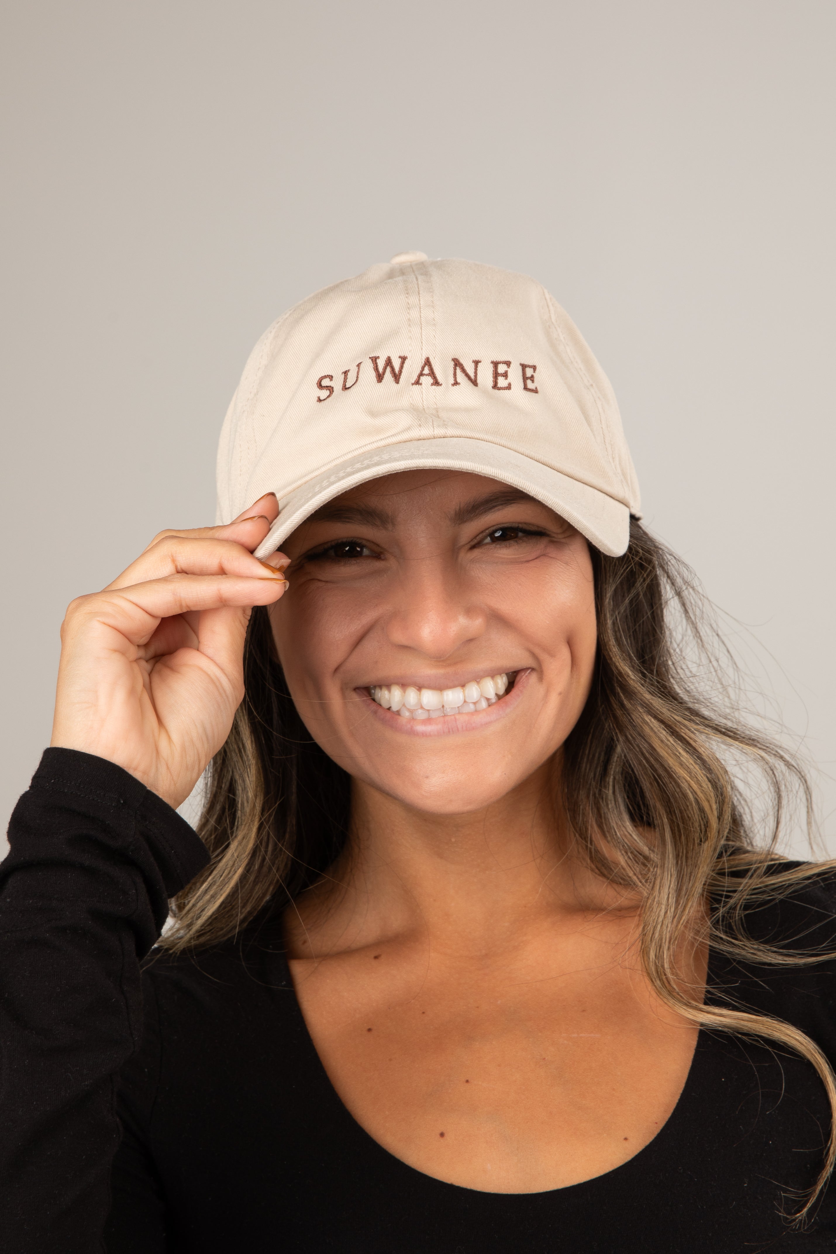 Woman wearing a beige cap with &