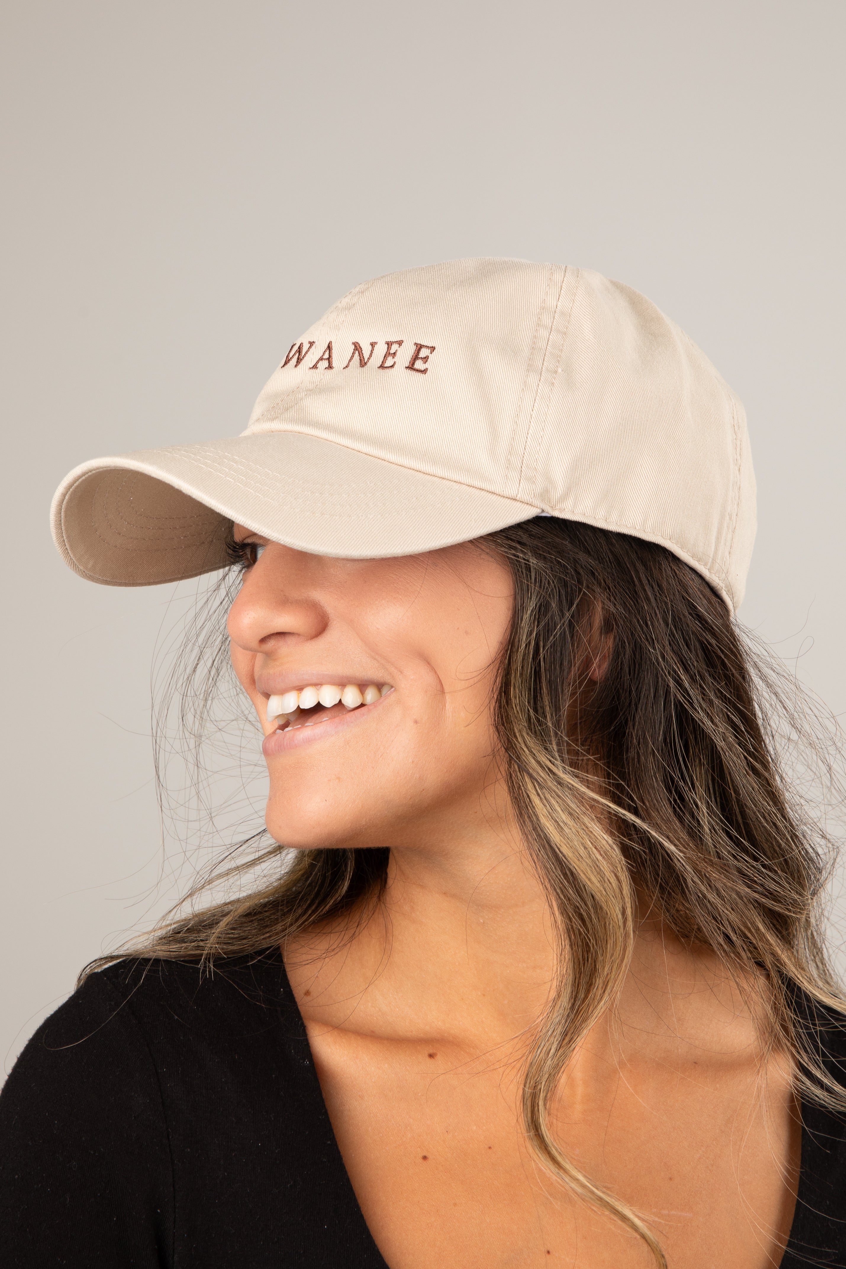 Woman wearing a beige cap with &