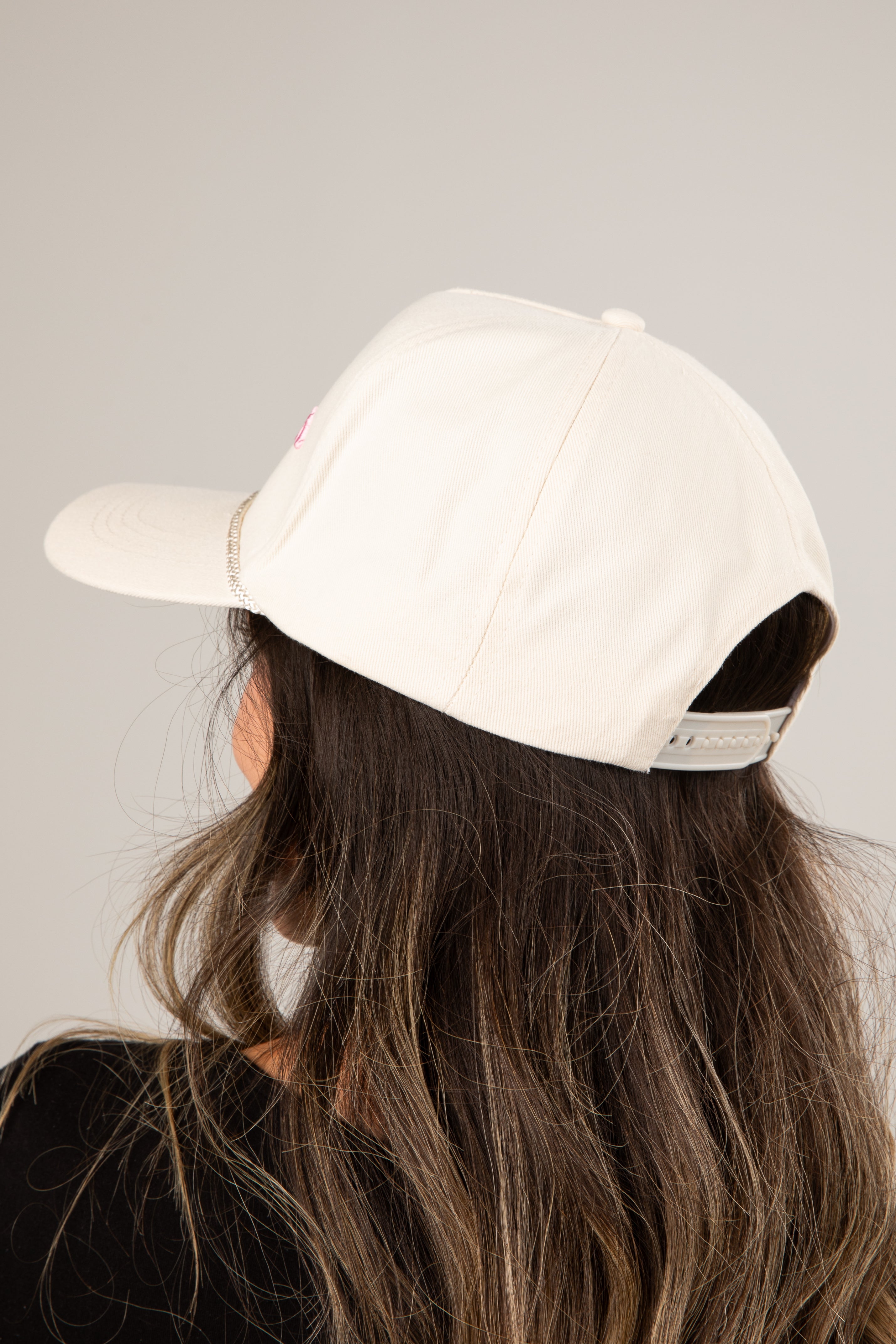 Person wearing a beige cap on a plain background