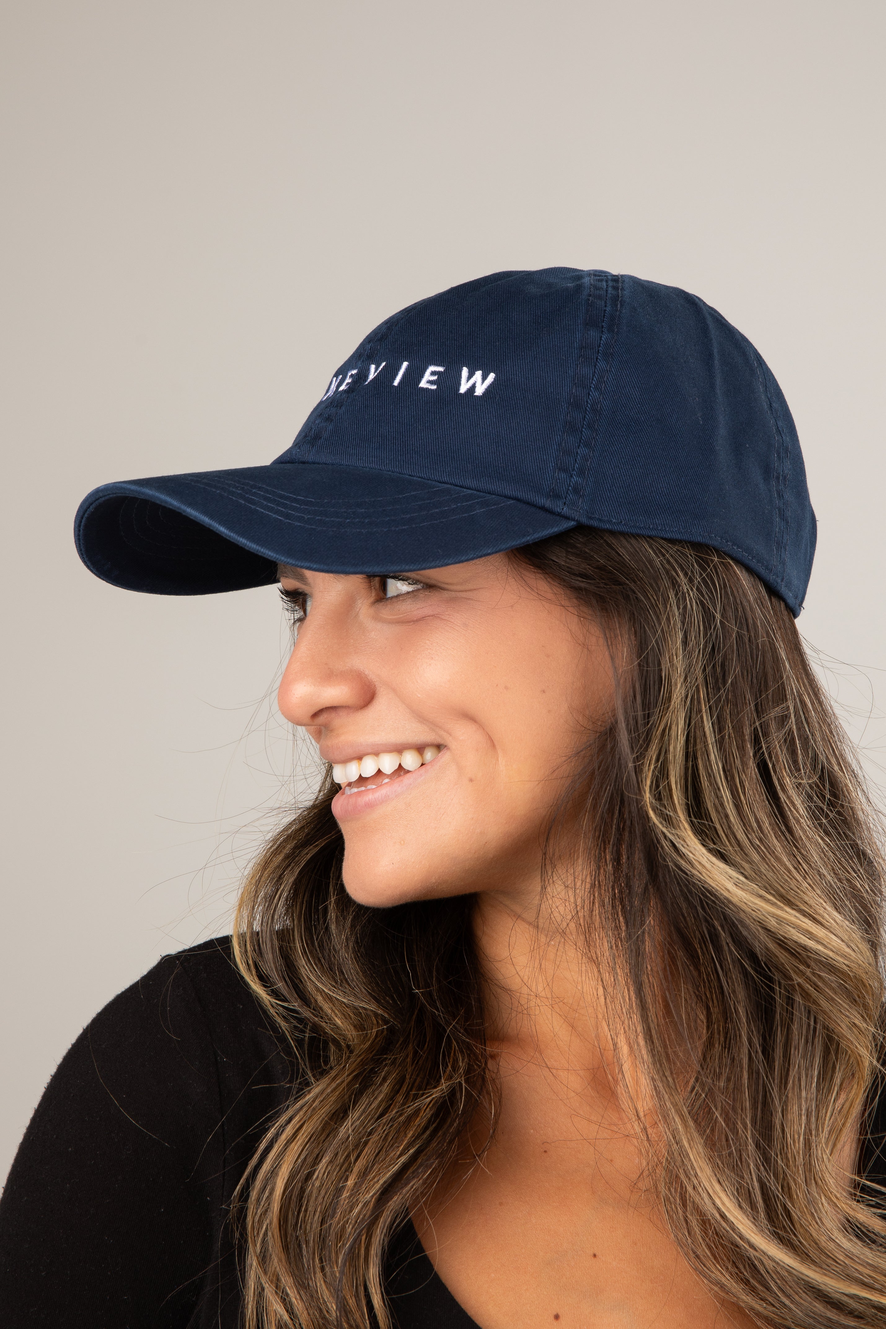 Woman wearing a navy blue cap with &
