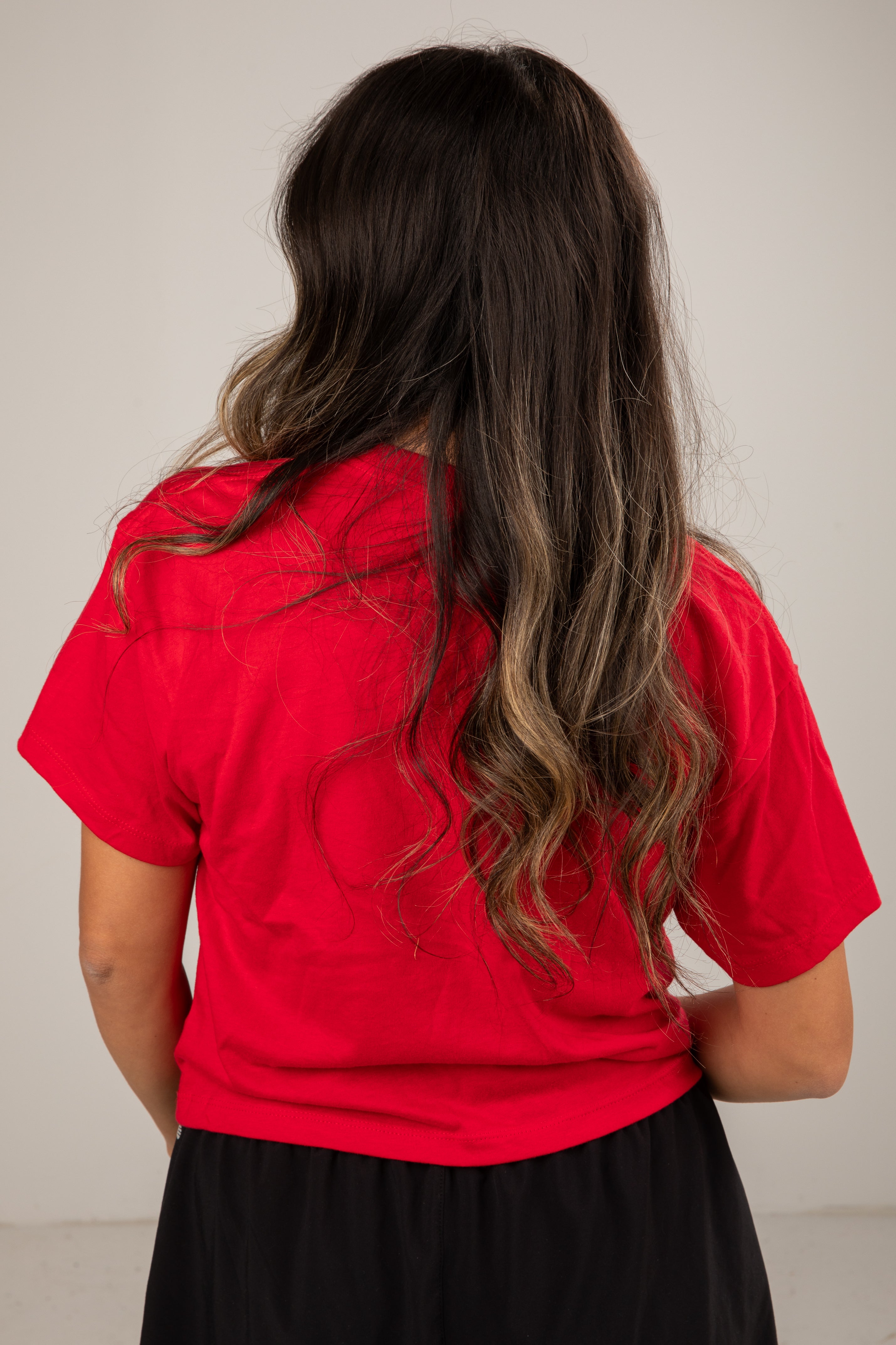 Person wearing a red shirt with a neutral background