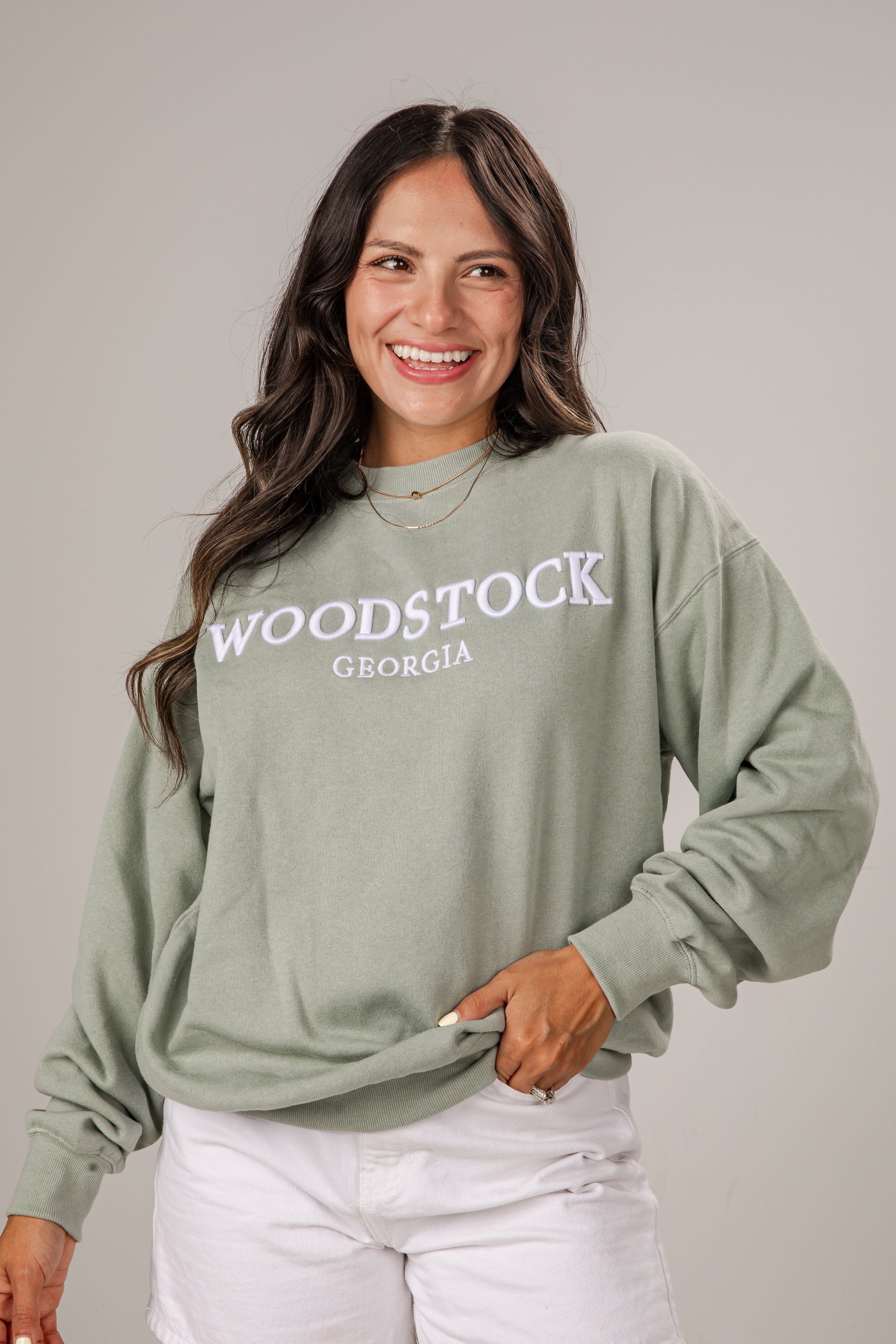 Woman wearing a green sweatshirt with &