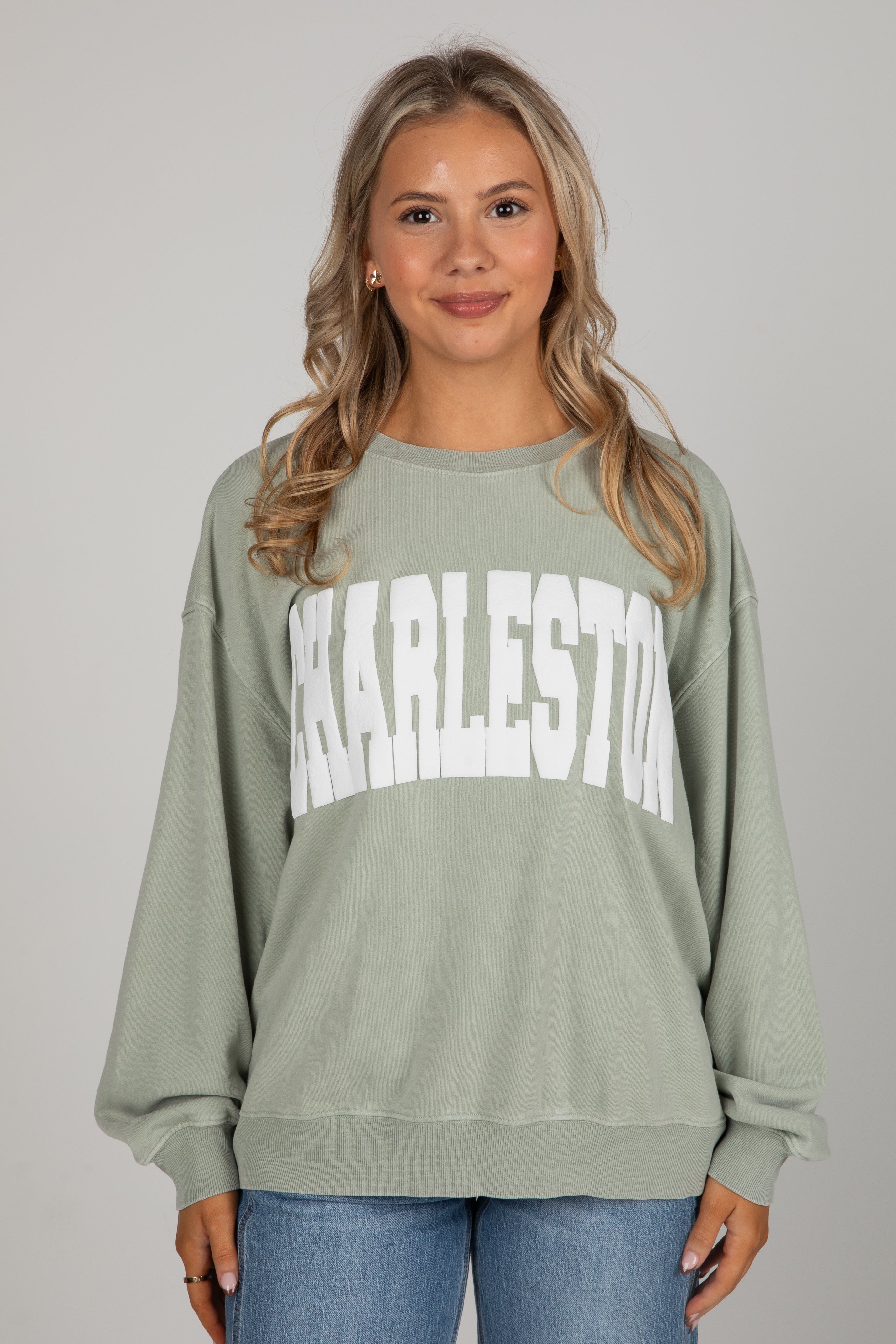 Woman wearing a green sweatshirt with &