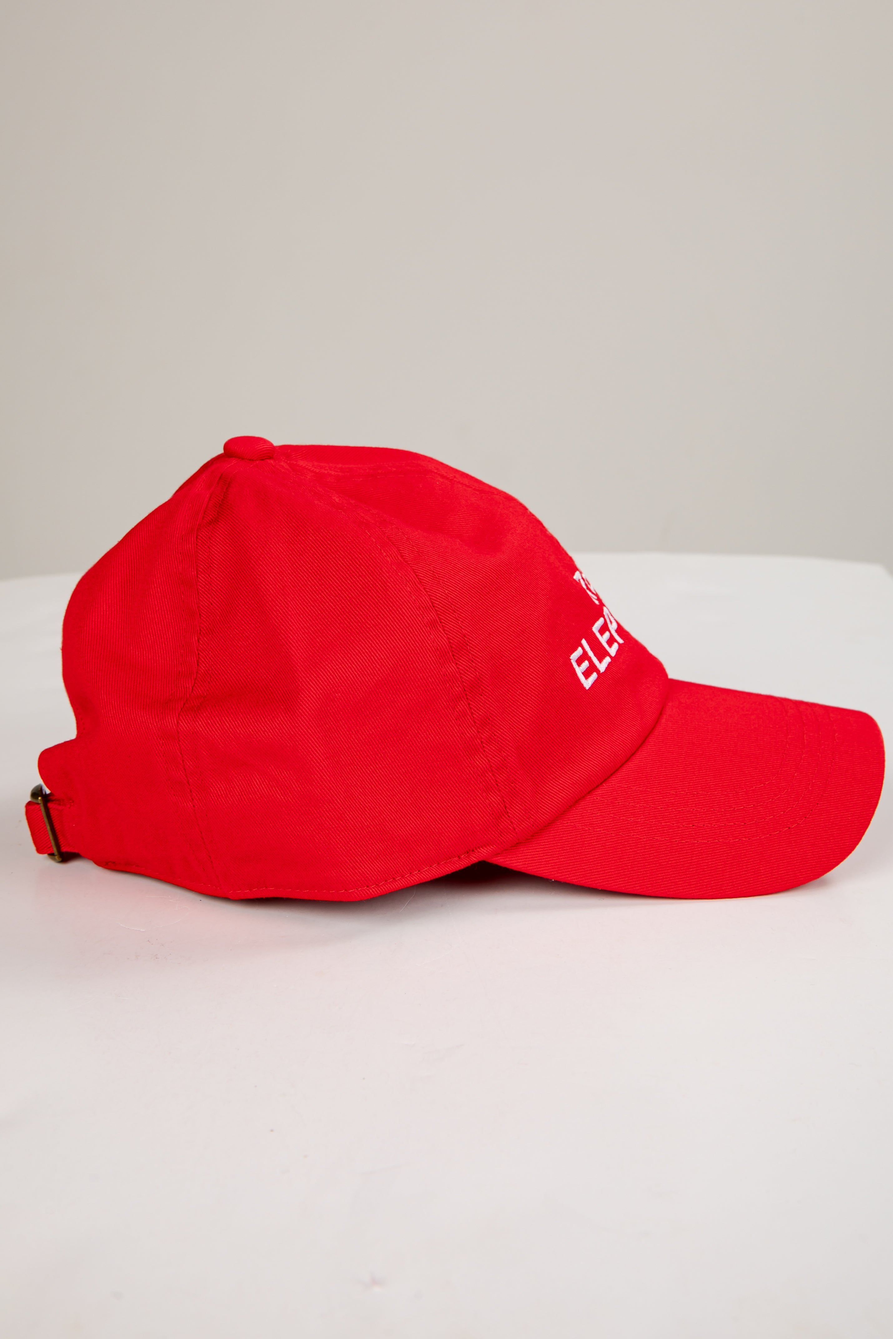 Red cap with a brand logo on a light gray background