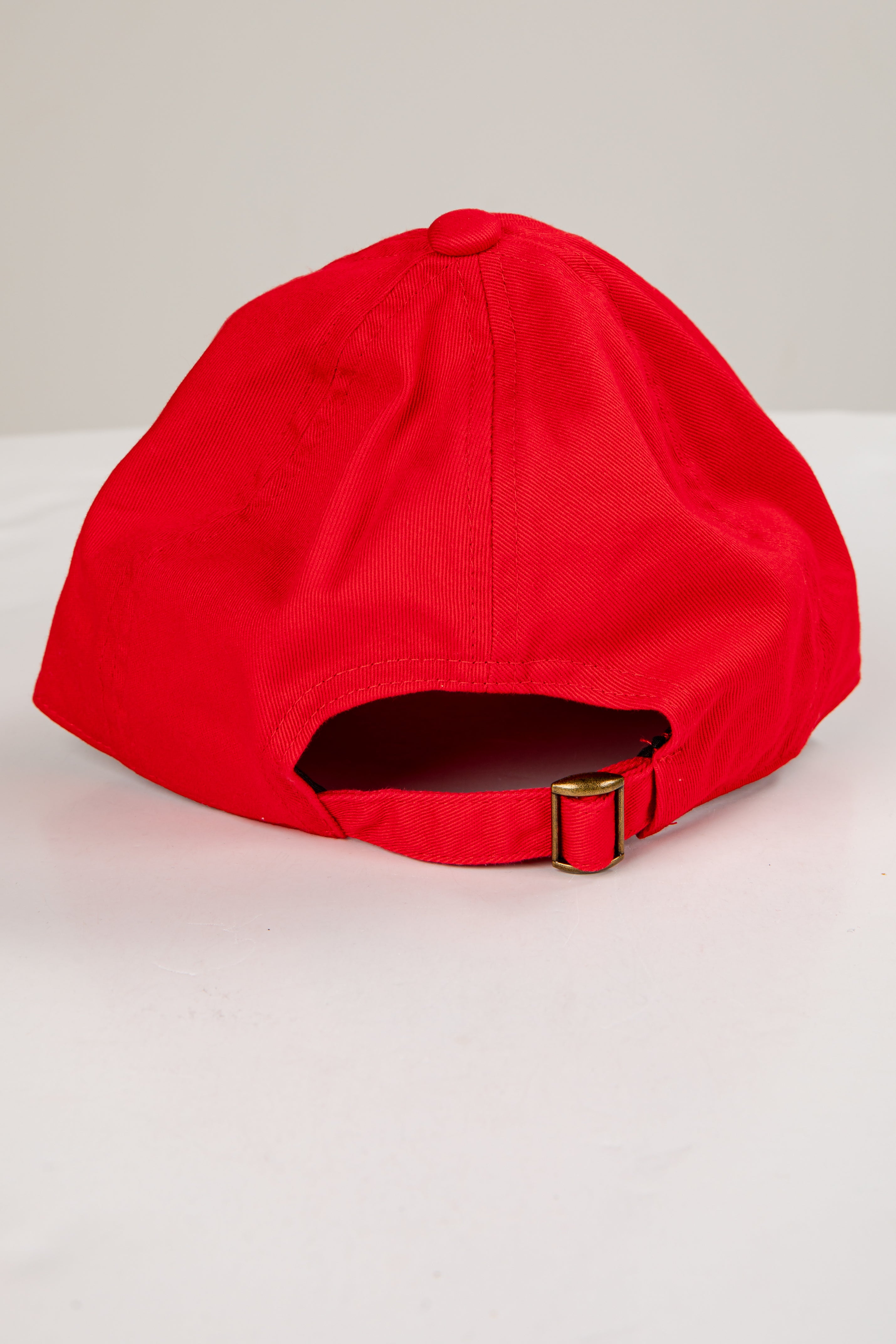 Red cap with a gold buckle on a light gray background