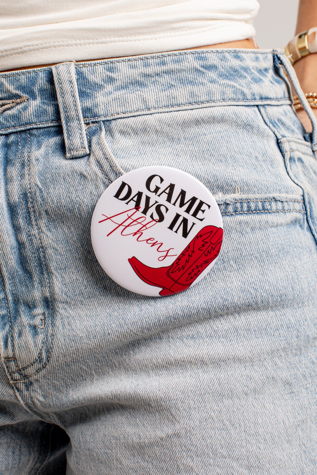 A round pin-back button badge with the text &