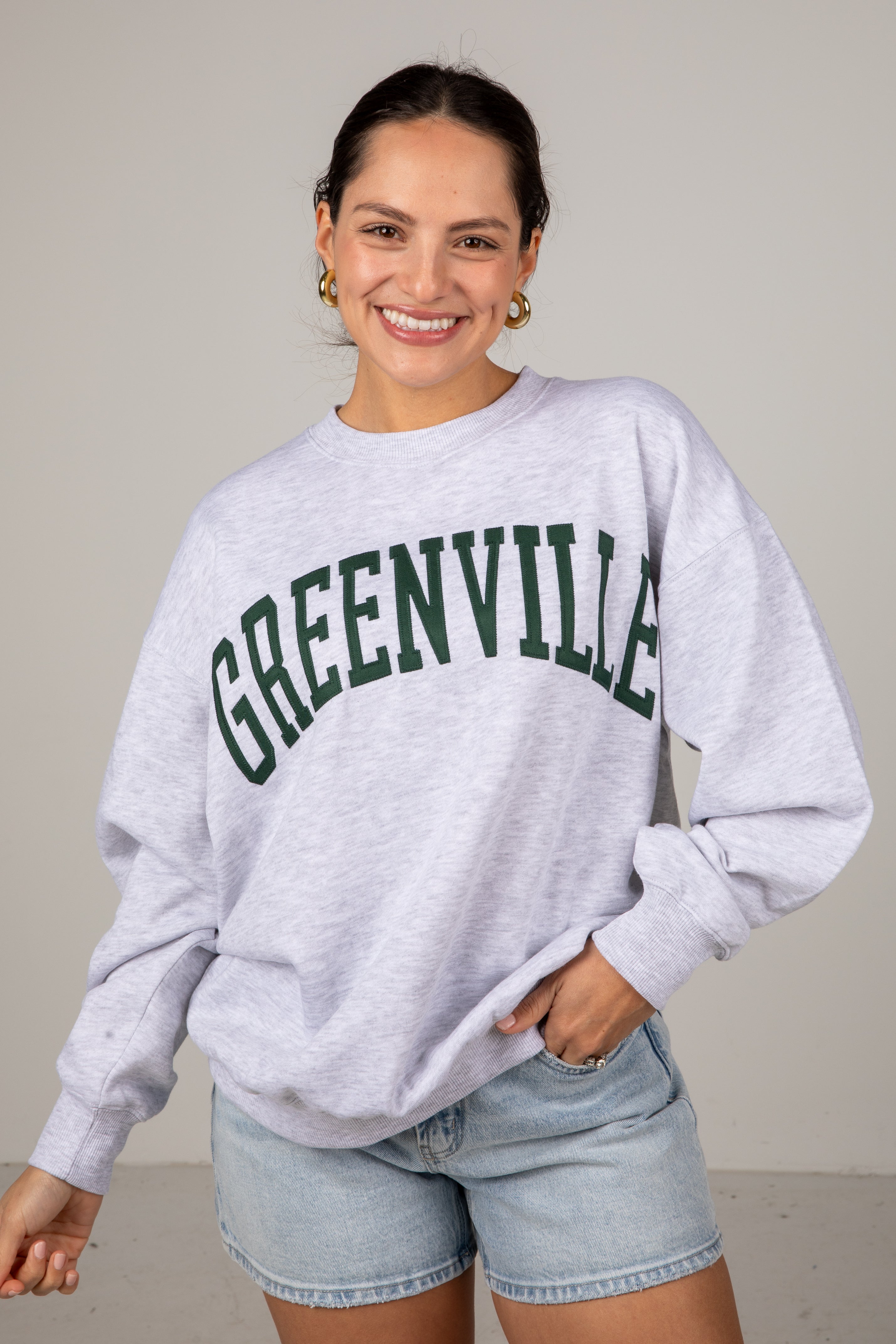 Woman wearing a gray sweatshirt with &