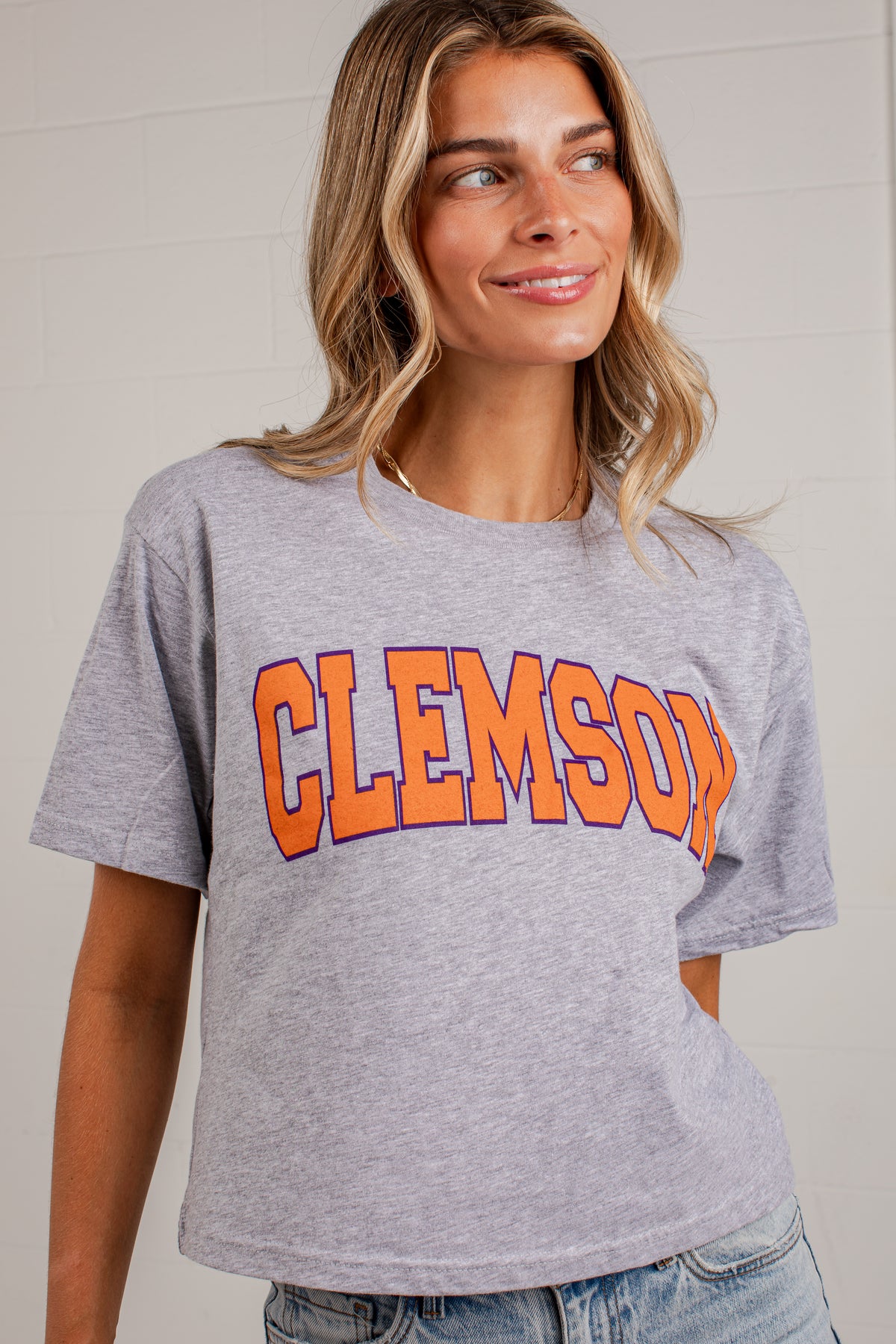 A woman wearing a heather gray short-sleeve t-shirt with &