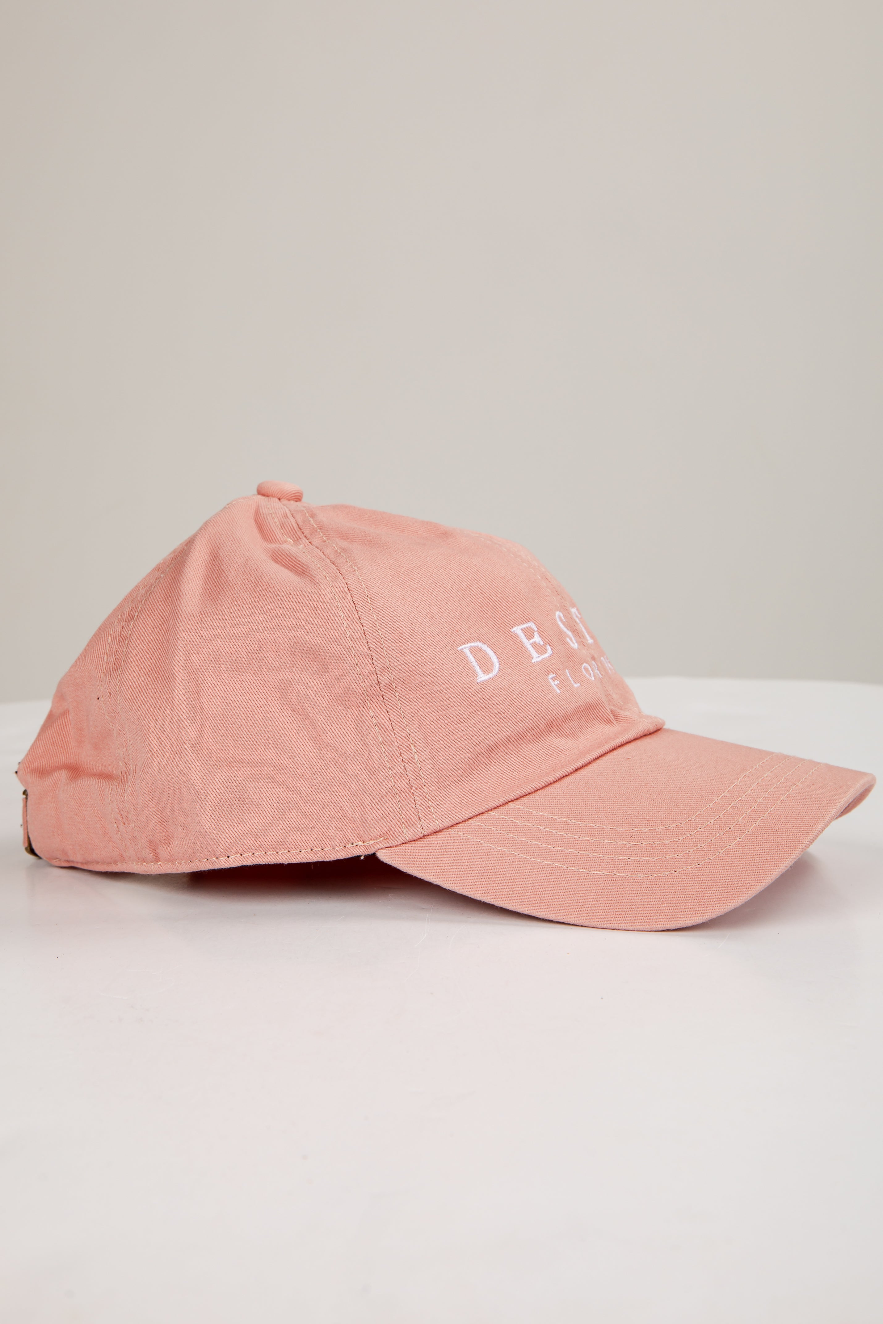 Pink cap with text on a light gray background