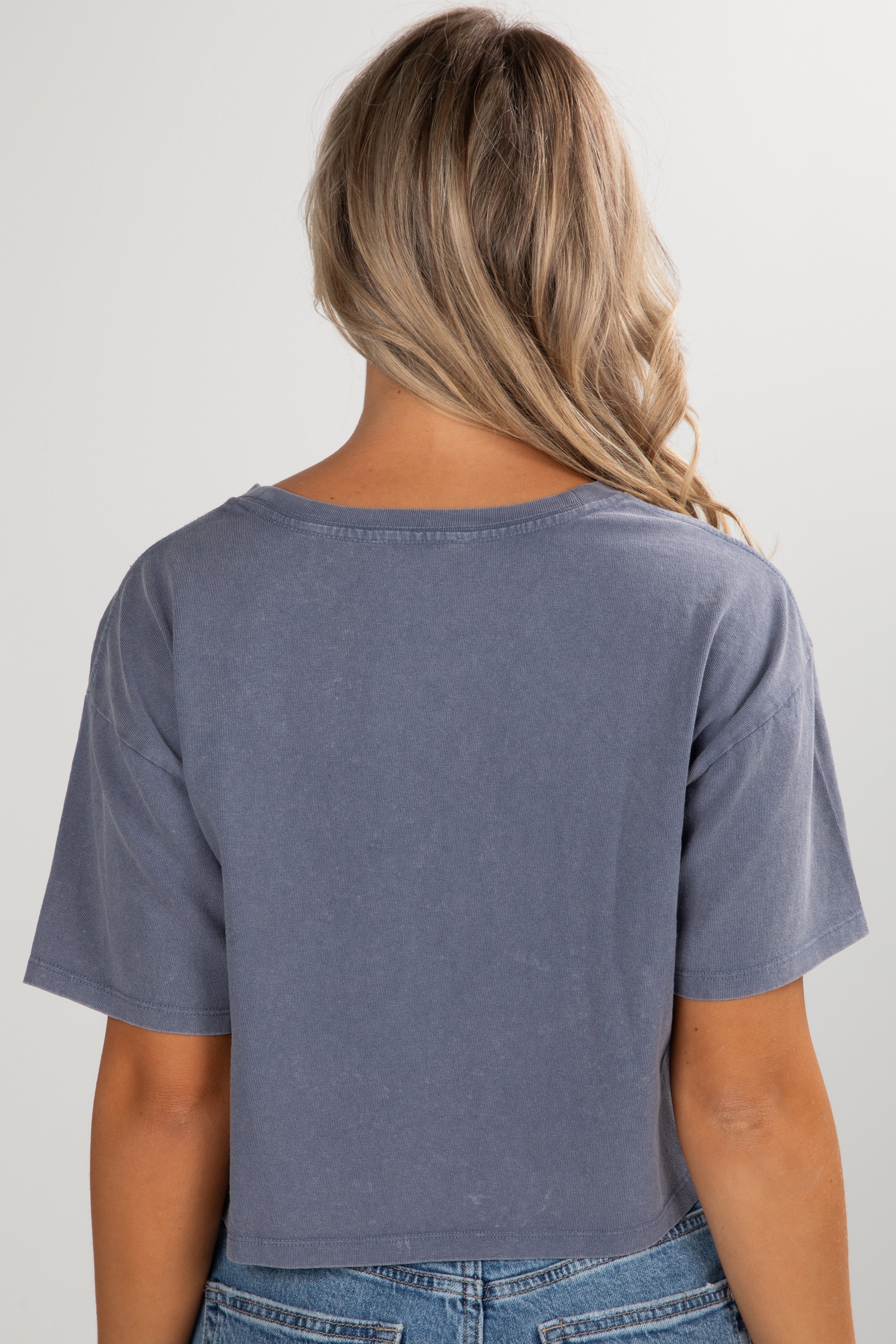 Person wearing a blue t-shirt and jeans on a plain background