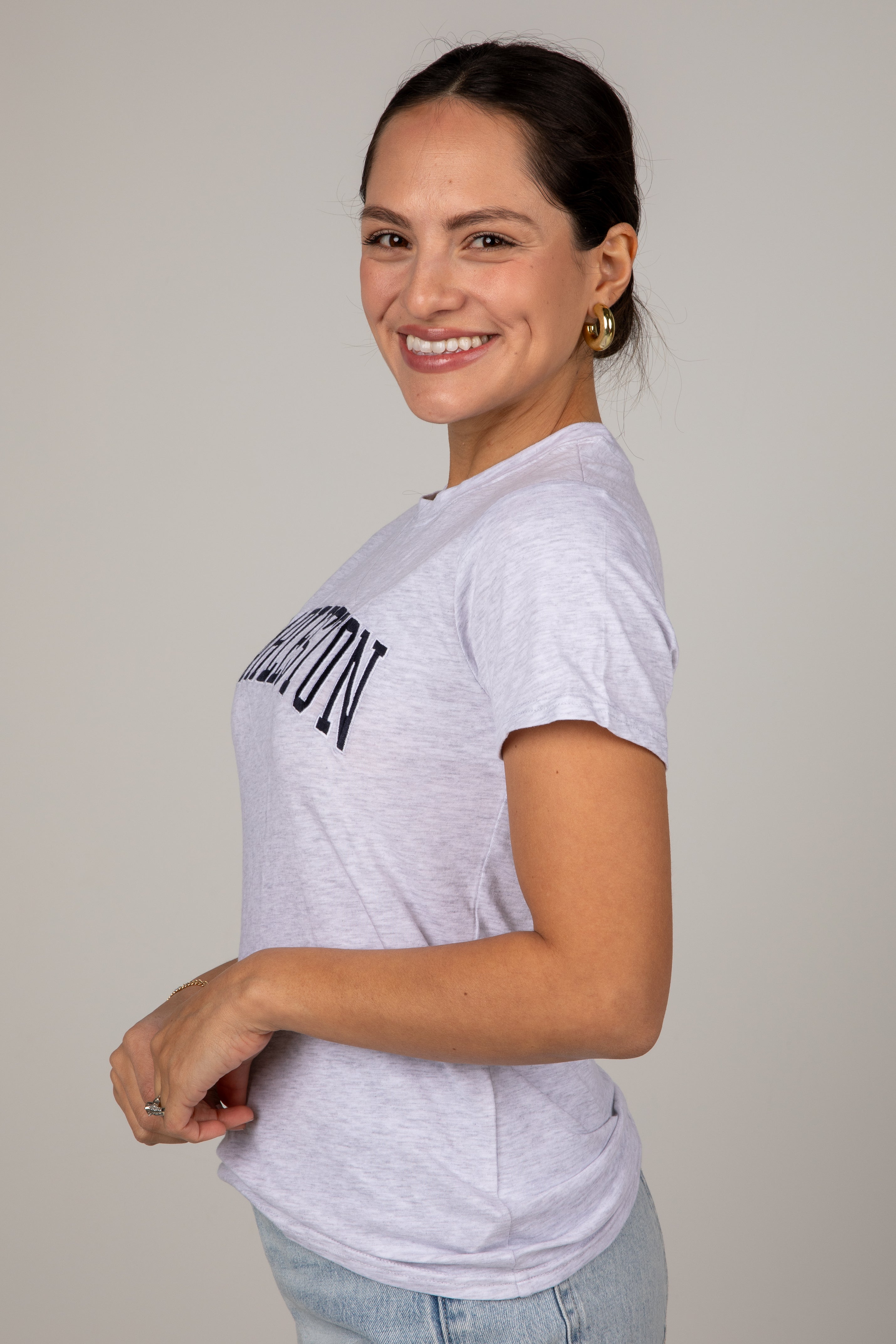 Woman wearing a white t-shirt with text on a plain background