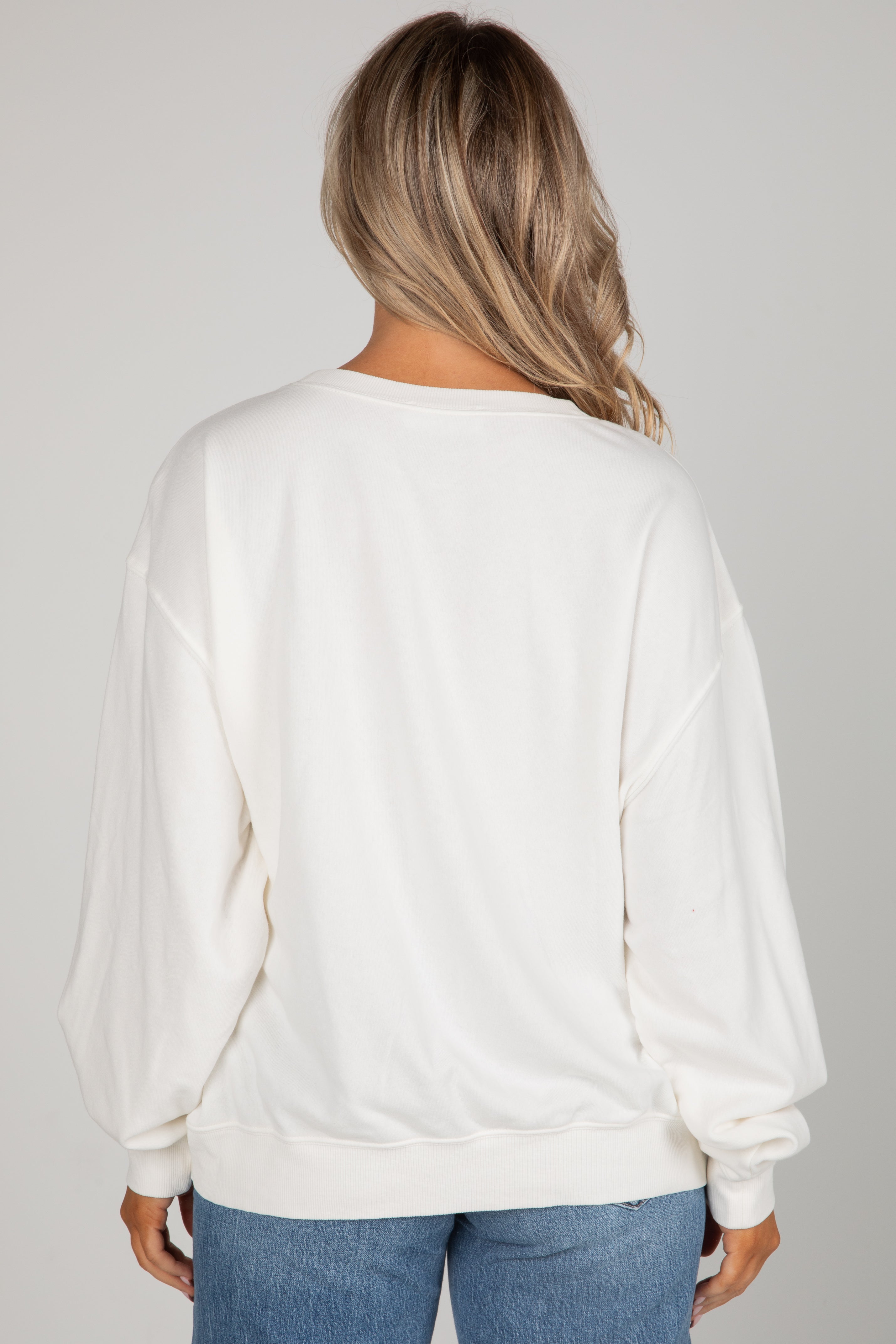 Person wearing a white blouse with long sleeves on a gray background