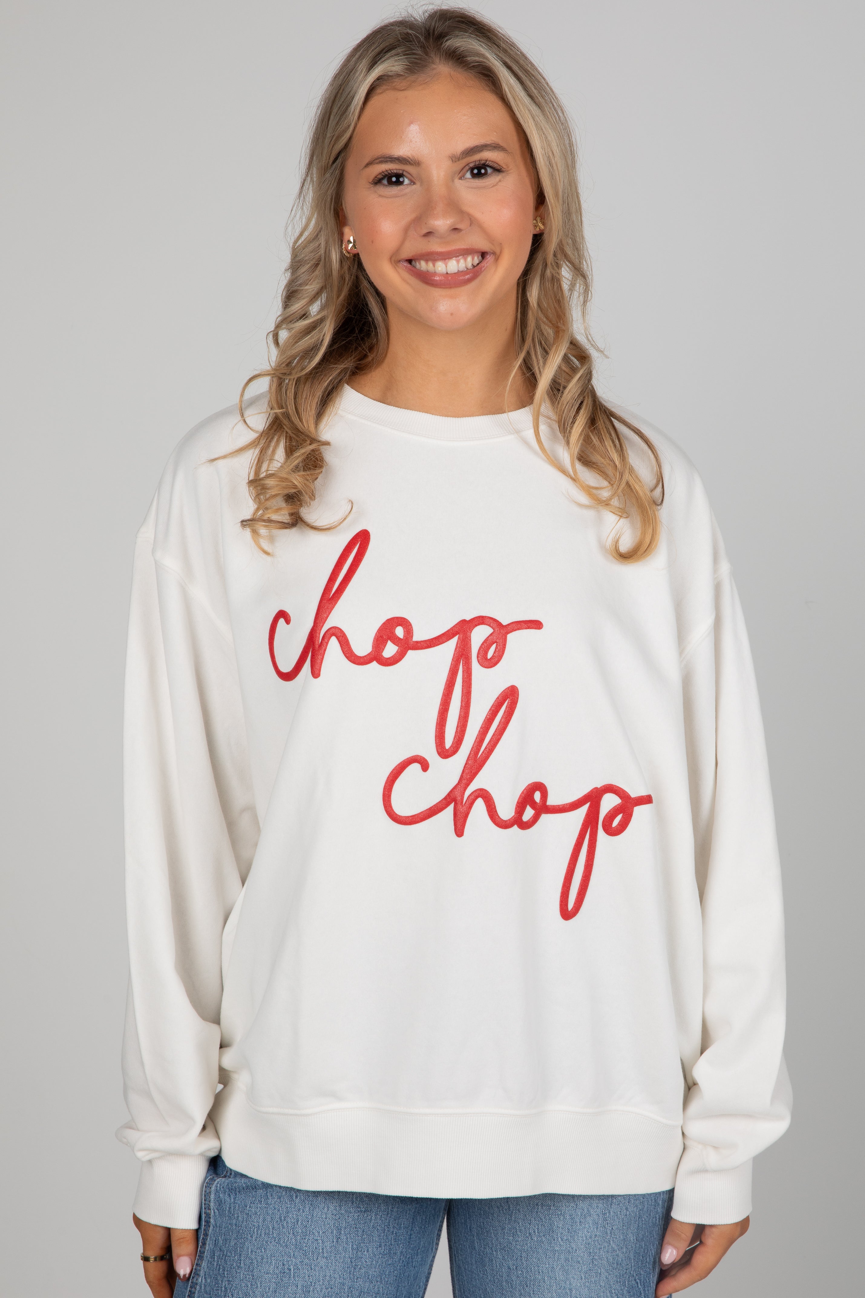 Woman wearing a white sweatshirt with &