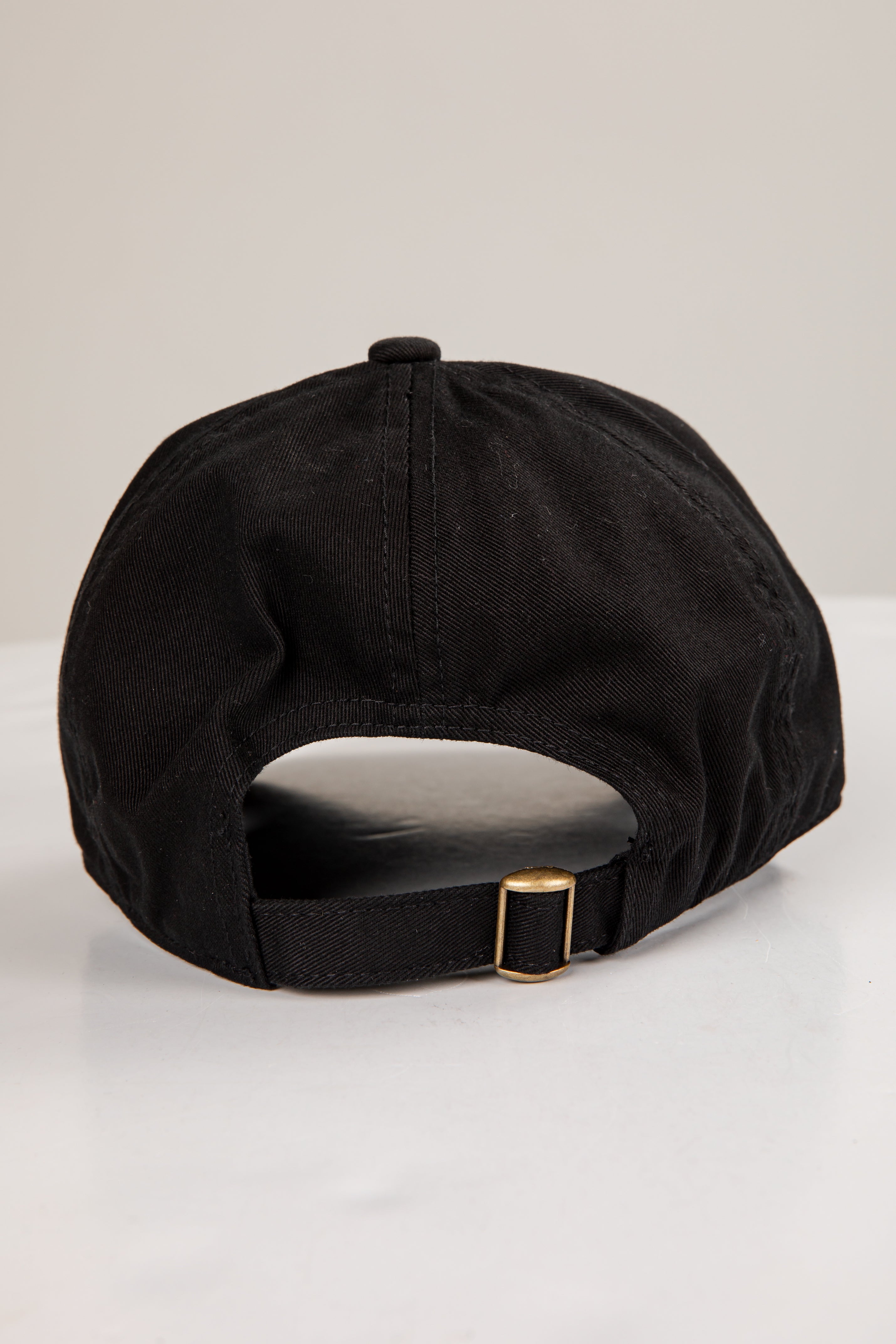 Black cap with a gold buckle on a white background
