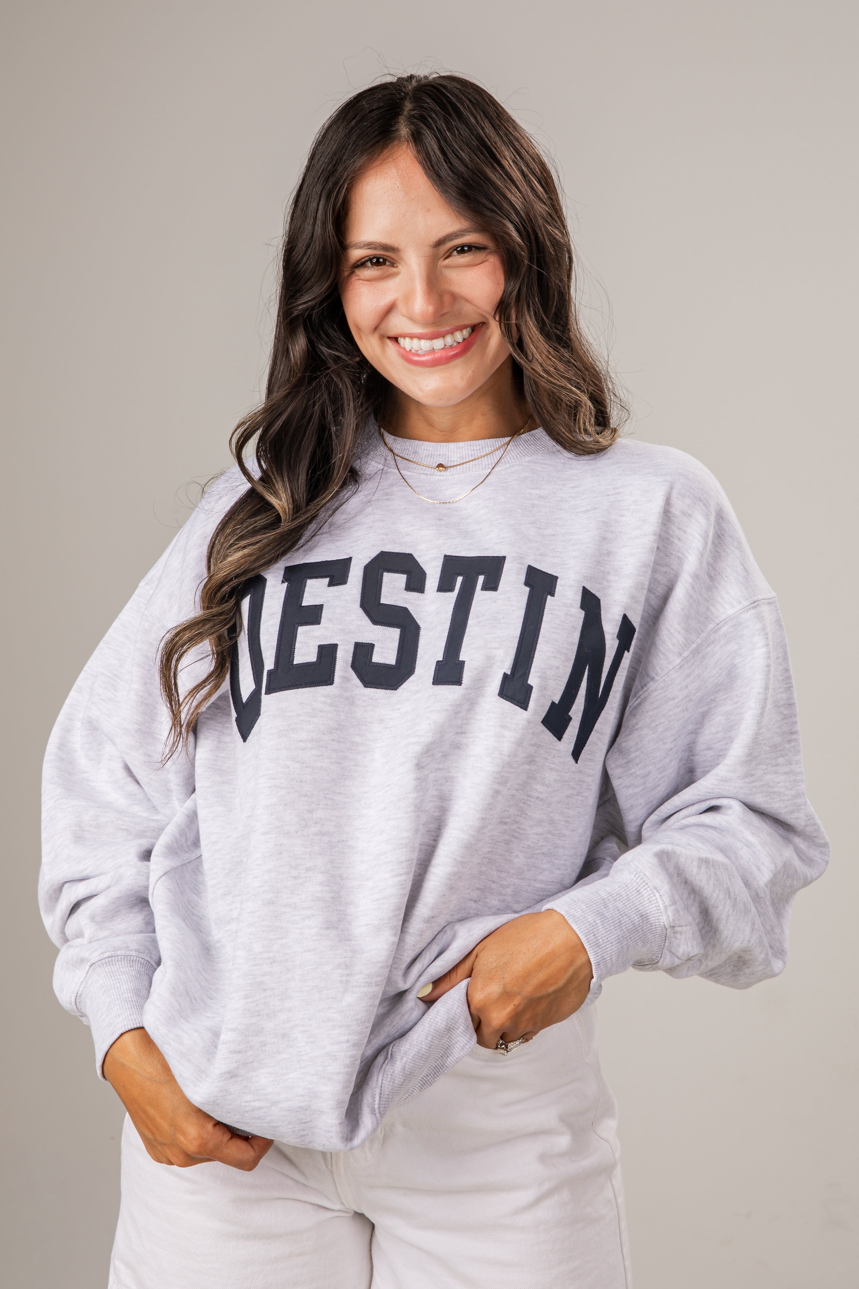 Woman wearing a gray sweatshirt with &