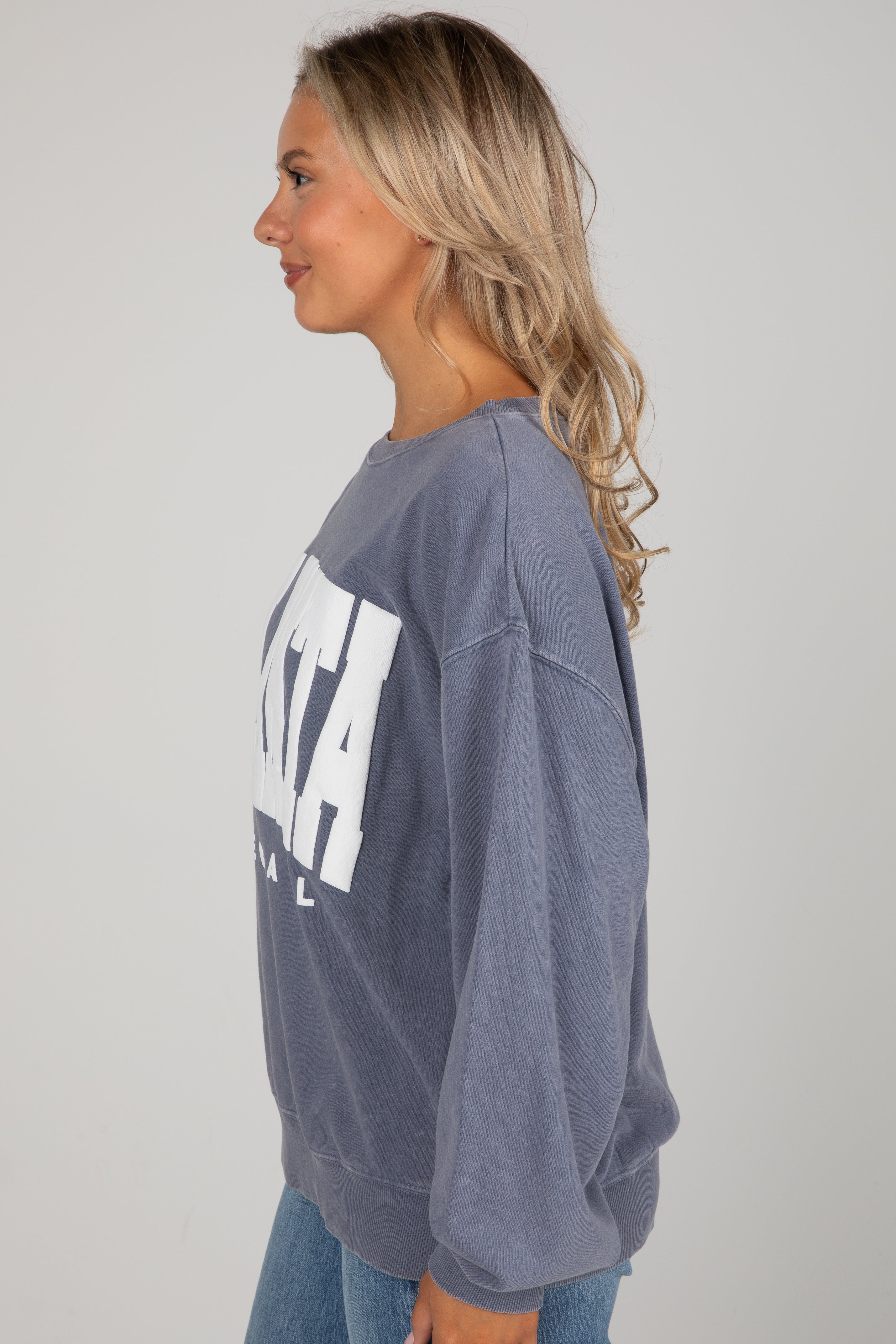 Woman wearing a gray sweatshirt with &